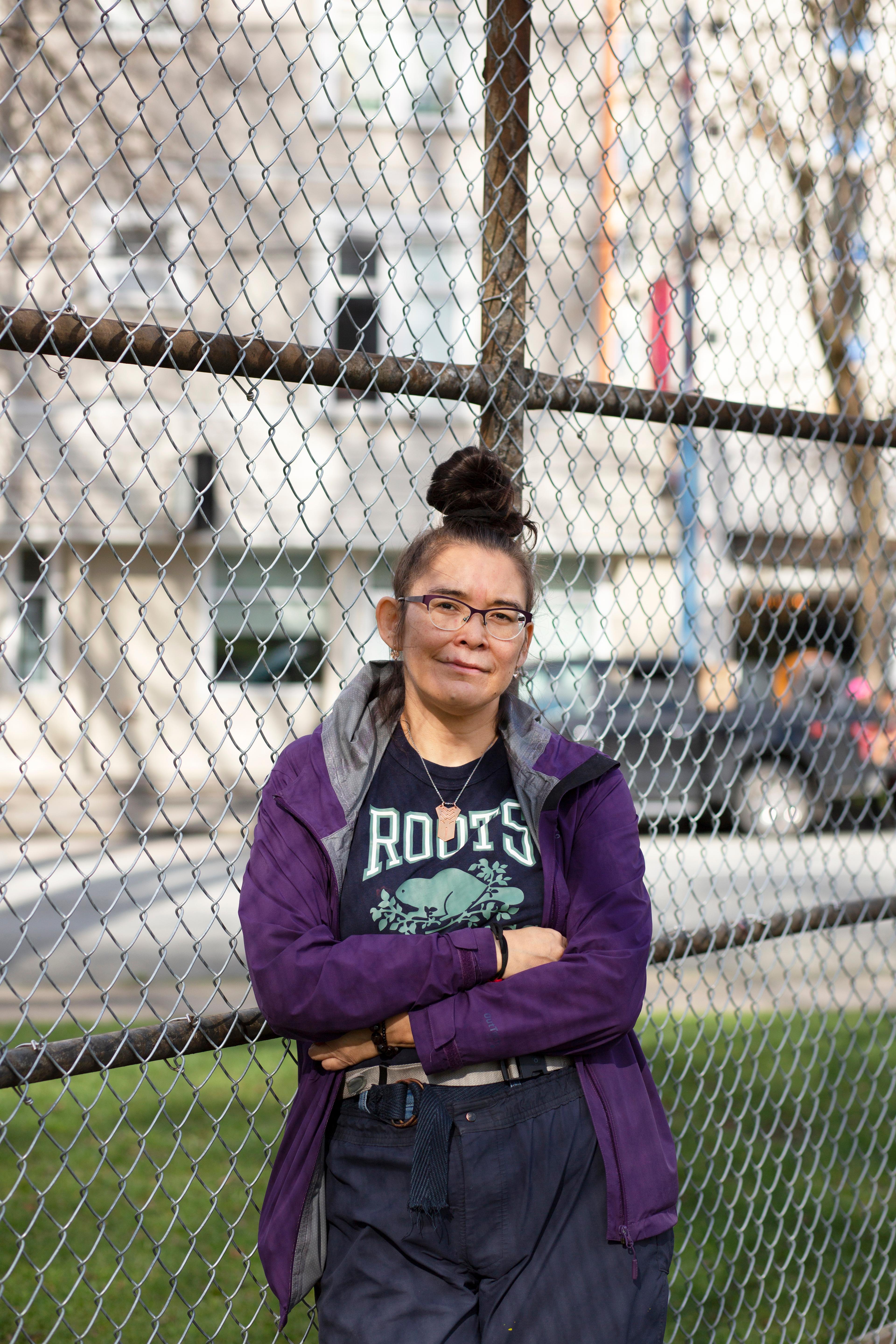 Woman standing in front of wire fence