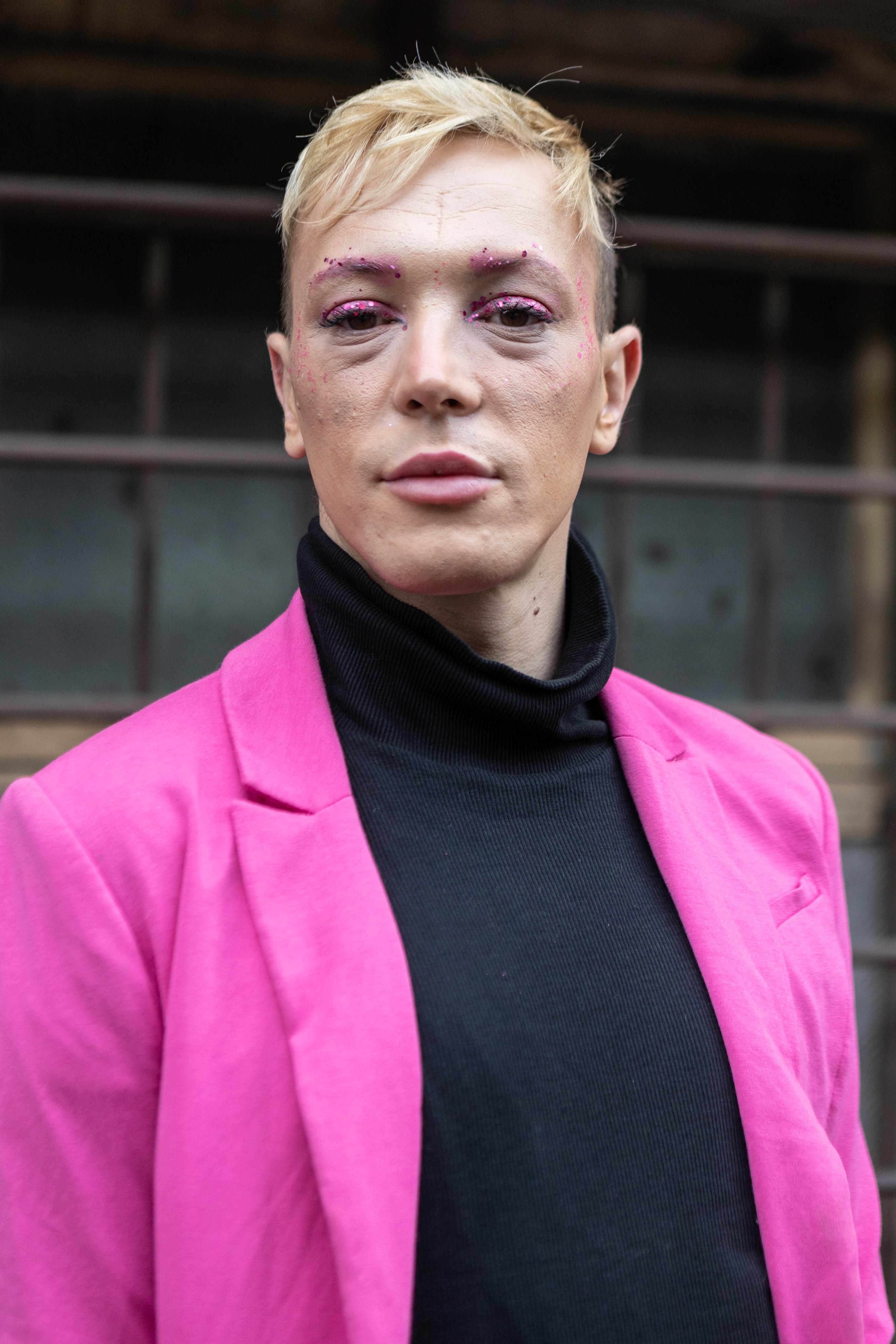 a portrait of a person wearing pink eyeshadow and a pink blazer