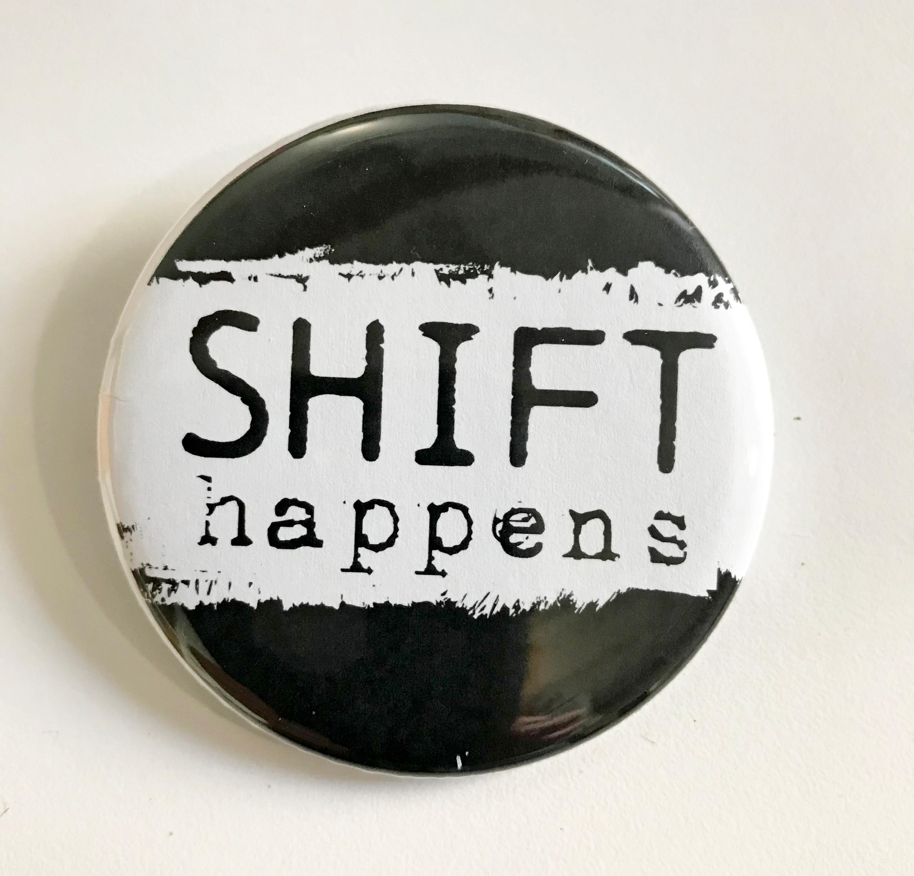 A badge with the slogan "shift happens"