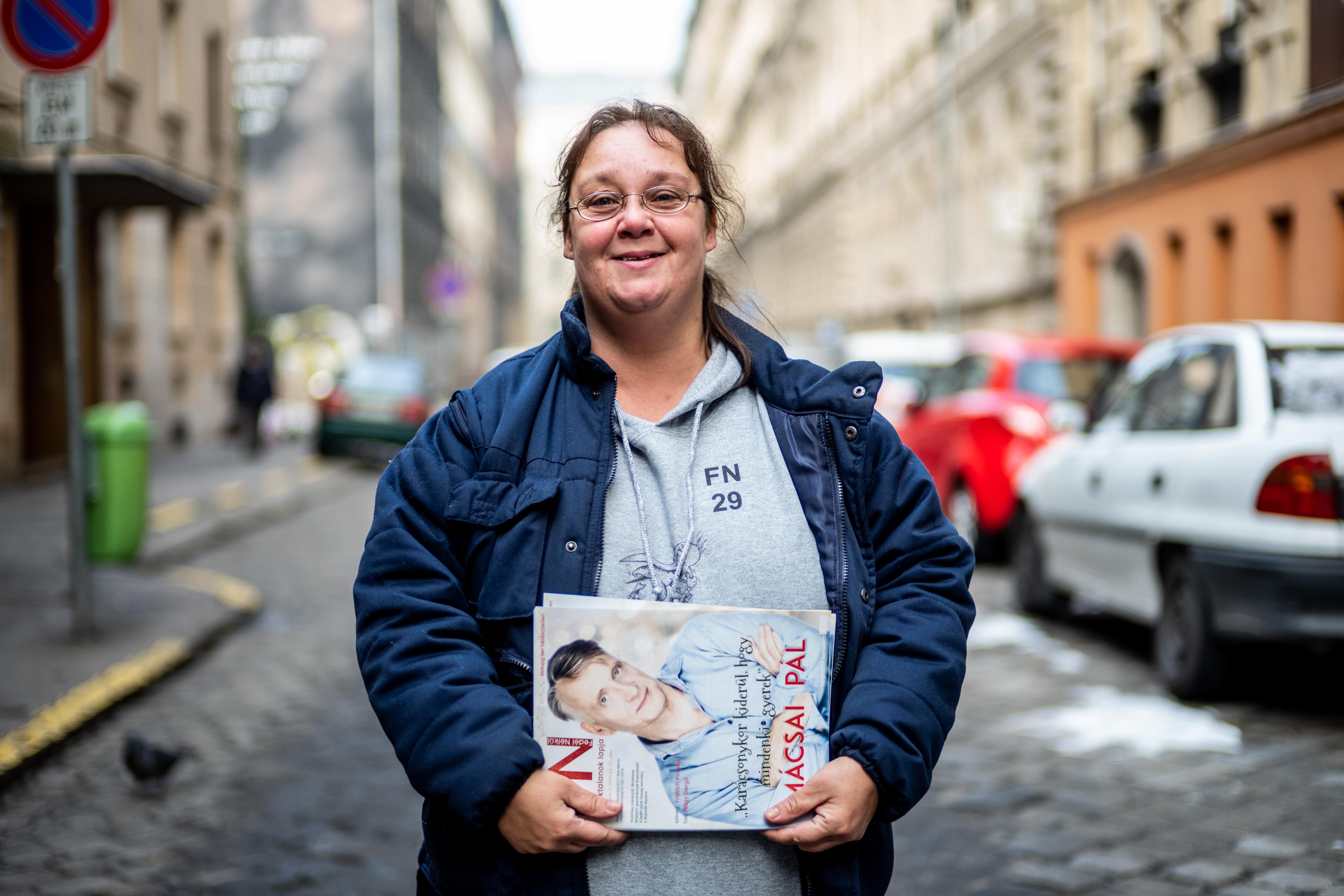 Csurika, a vendor with Fedél Nélkül street paper in Hungary, is pictured selling the magazine on a street.