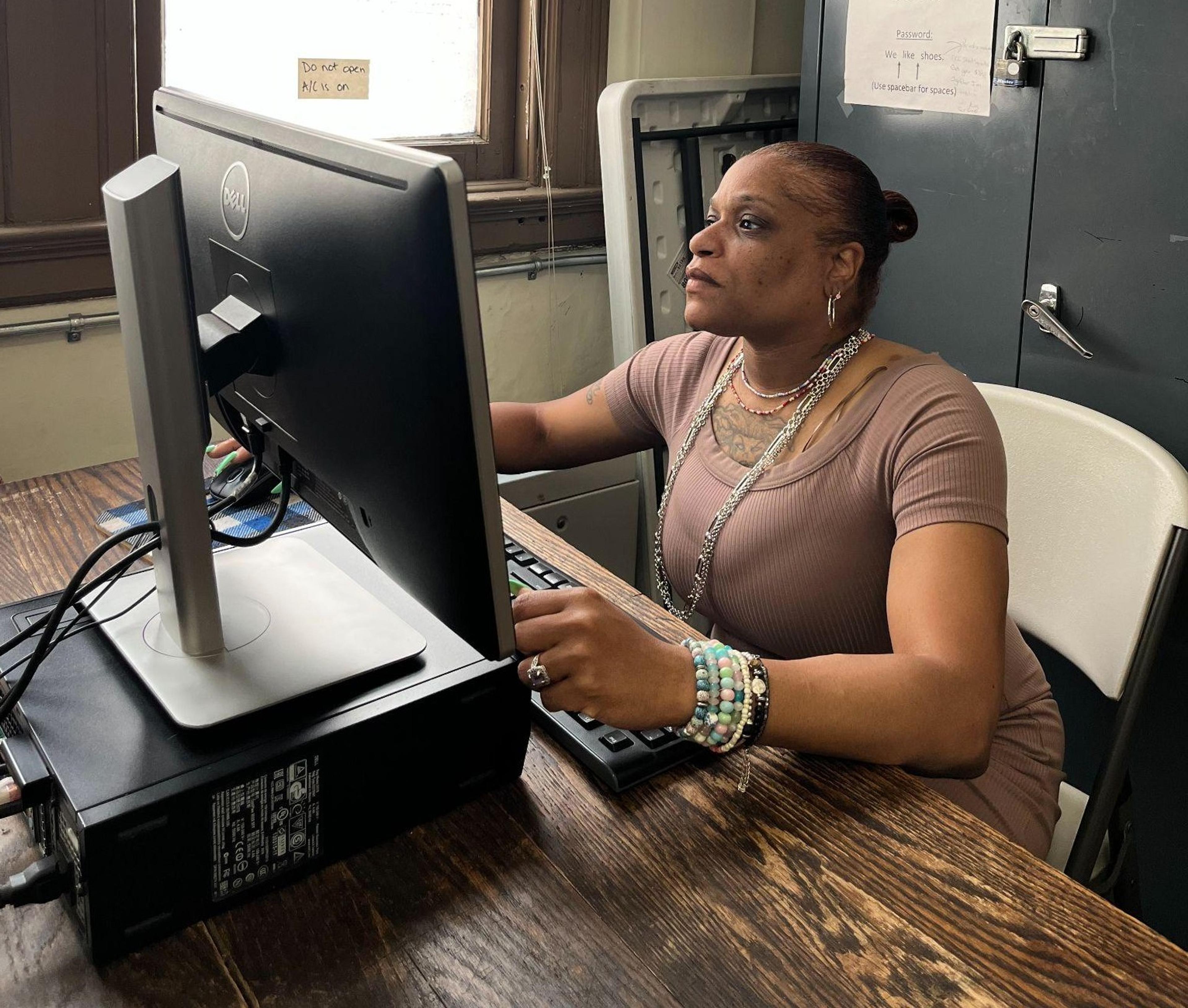 Nikki Smith sits at a desk working on a computer