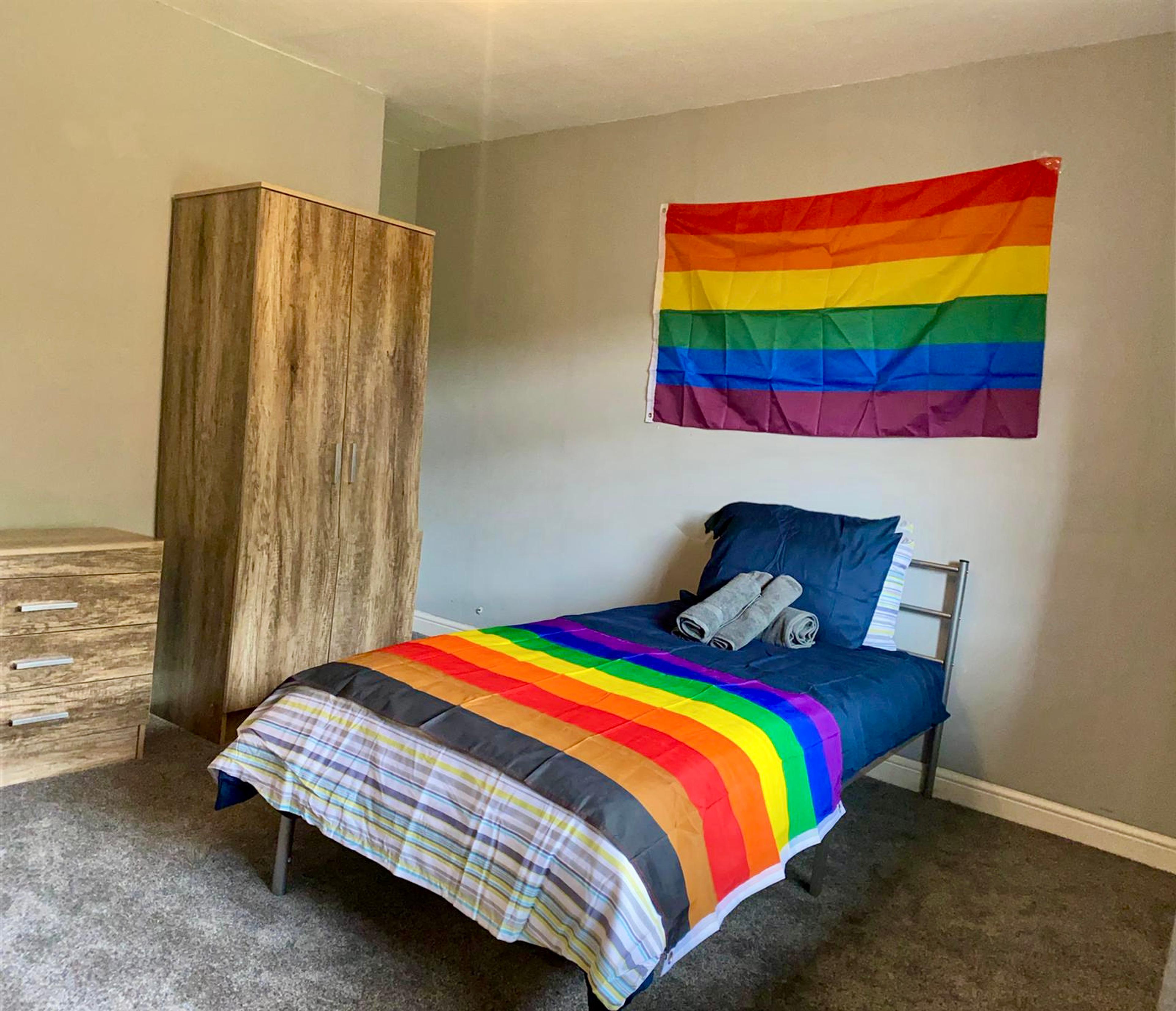 a bed with a rainbow quilt