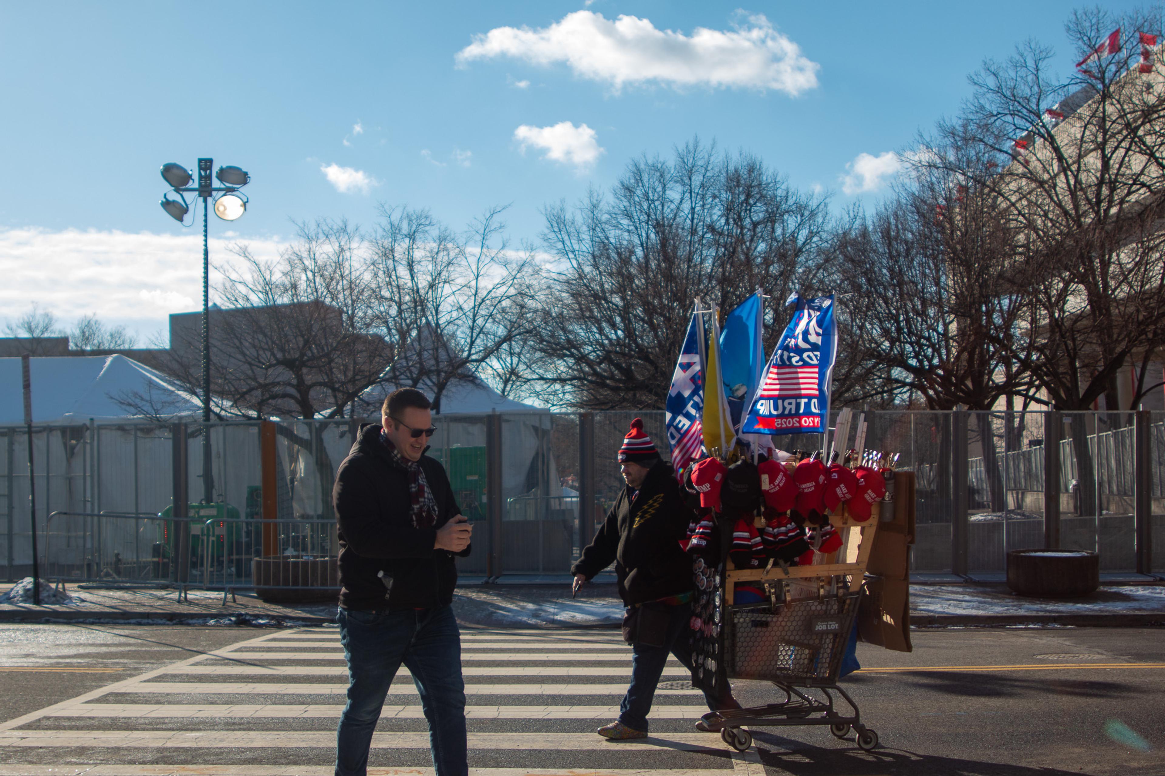 a picture of two men handing out trump merchandise 