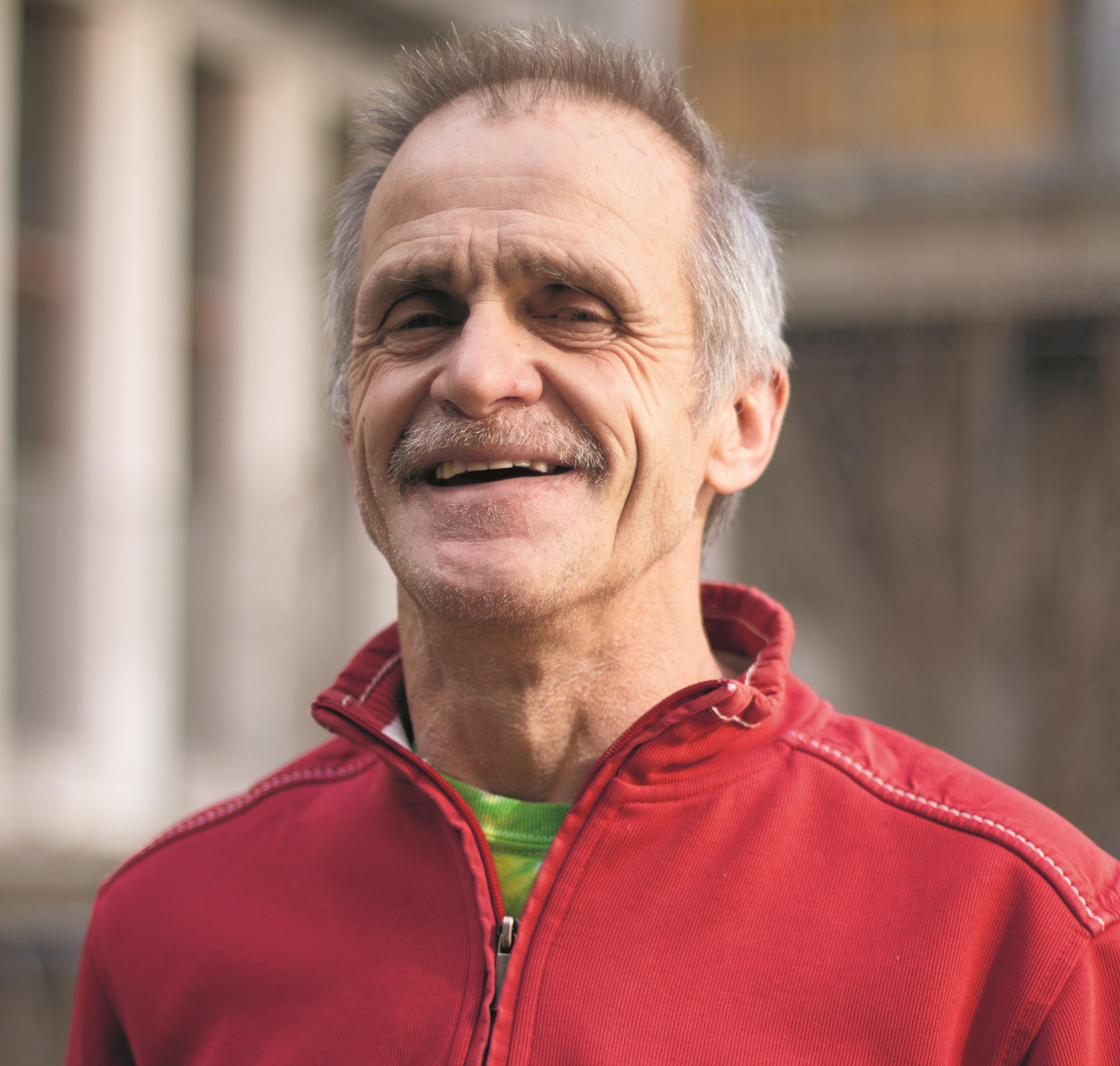 Swiss street soccer team member Heini Hassler smiles wearing a read pullover.