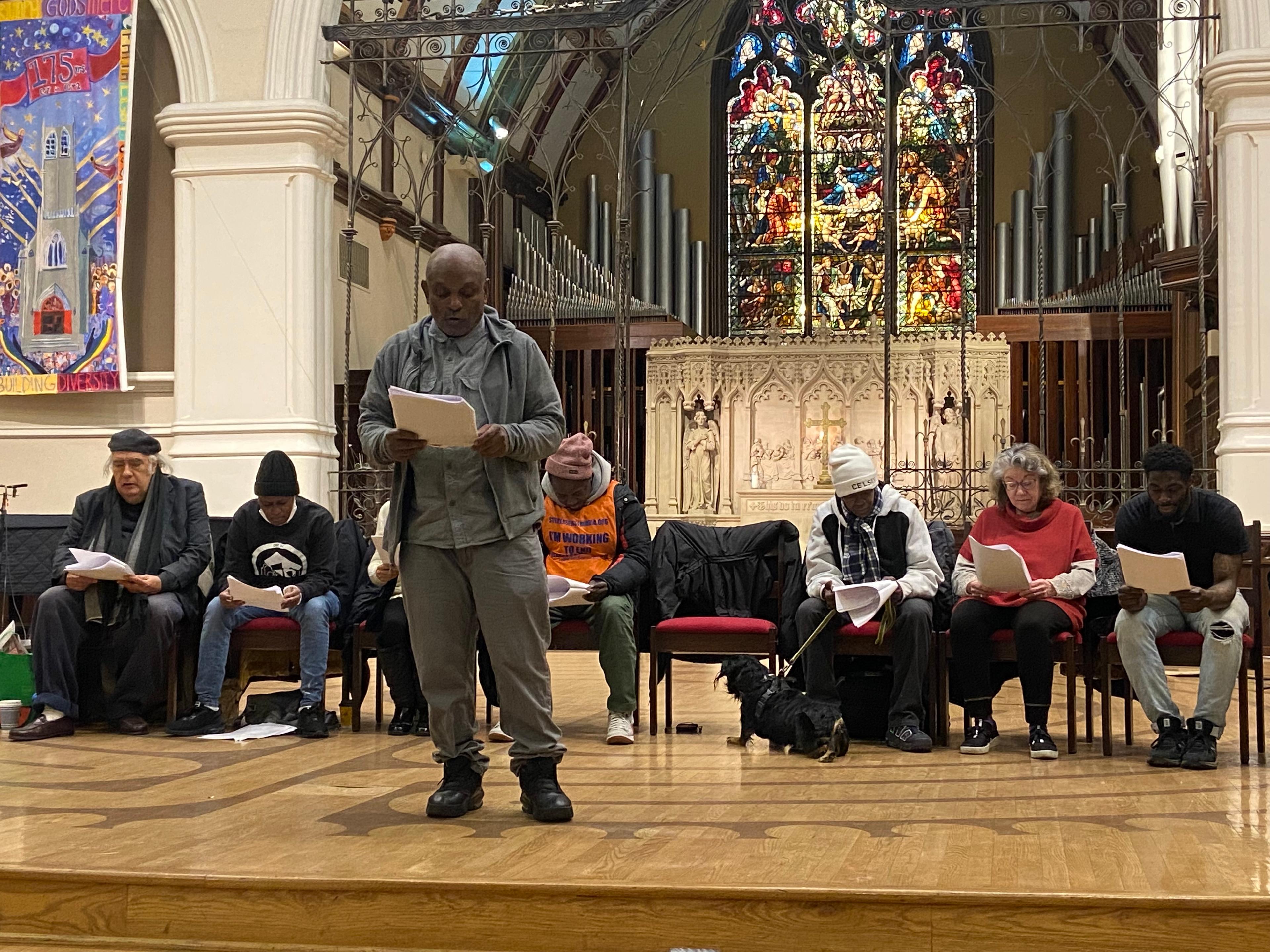 3.	Robert Warren, a vendor and leader for a local homeless rights activist group known as the People for Fairness Coalition recites lines from his monologue on stage with the other vendors taking part in the play.