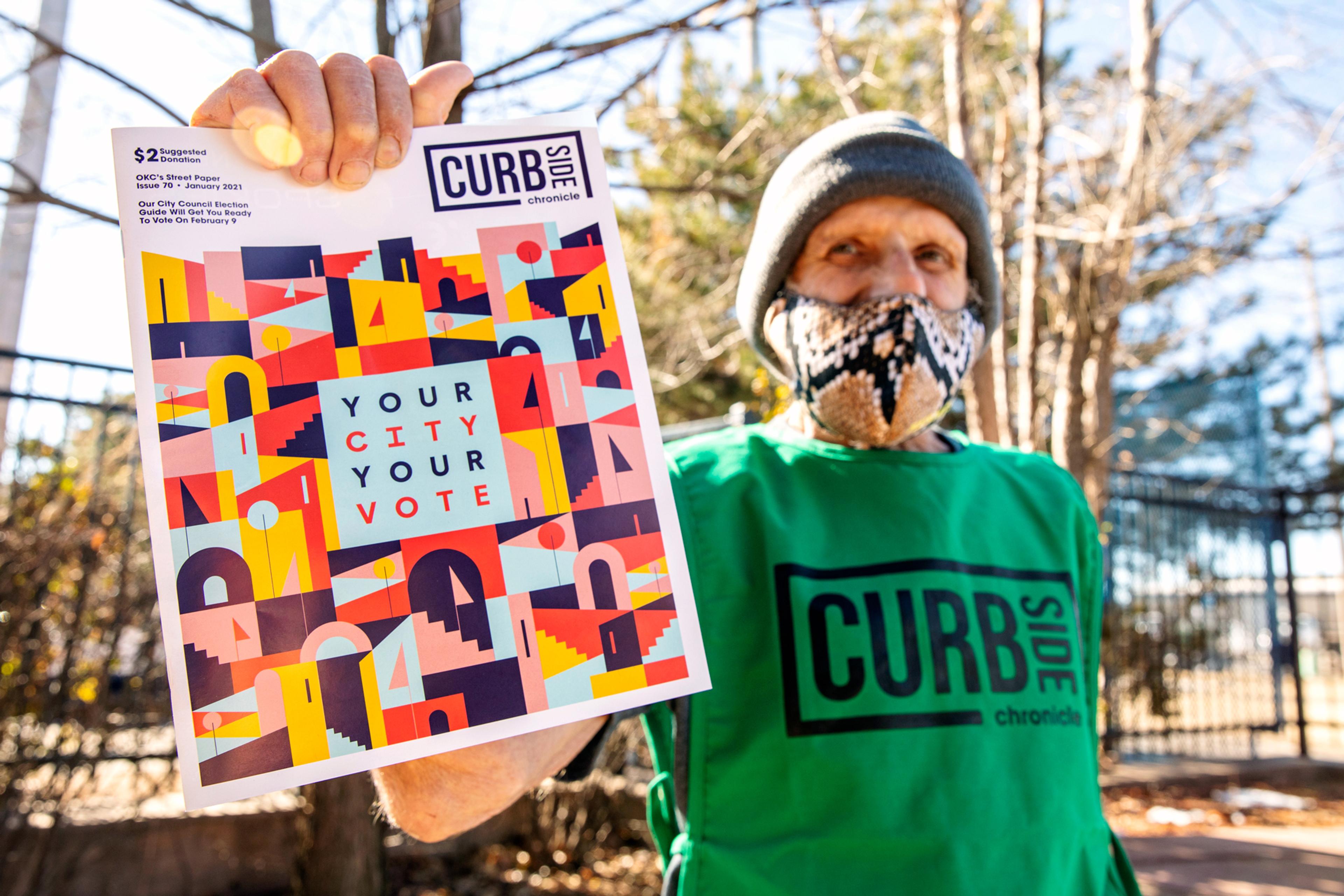 Man from Curbside Chronicle selling street paper