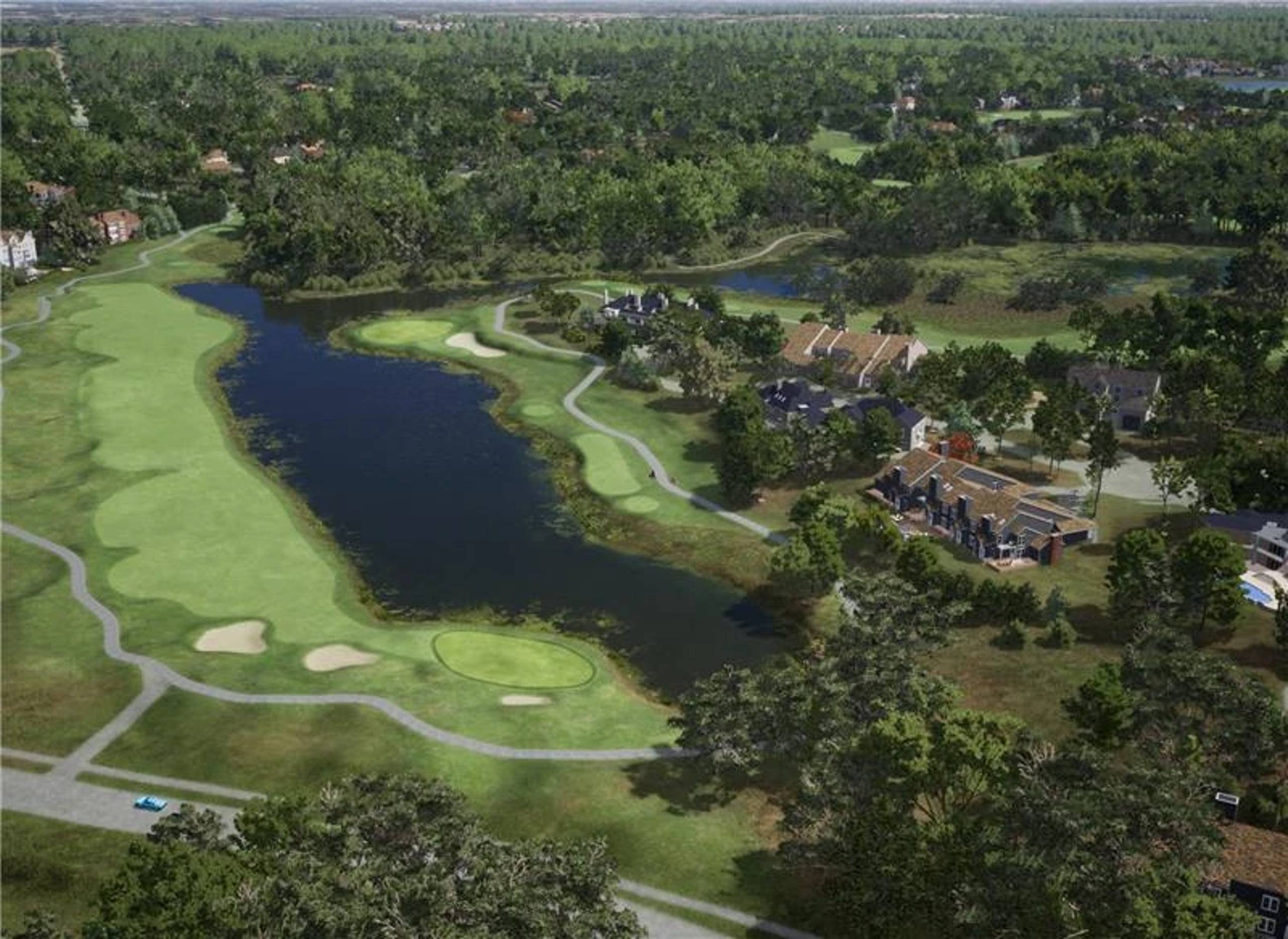 Aerial view of a golf course with a long lake, surrounded by houses and dense trees.