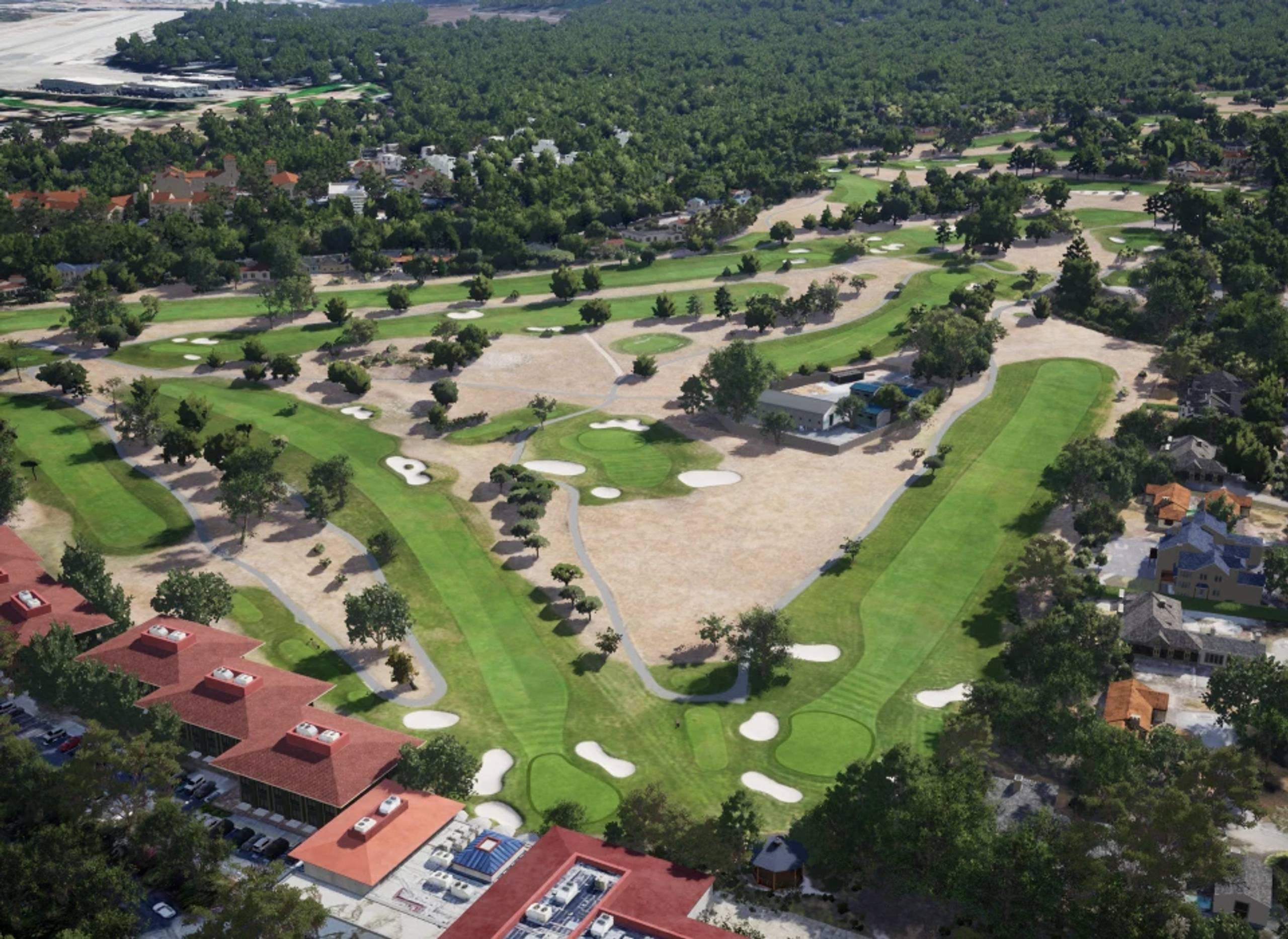 Aerial view of a golf course with green fairways, sand traps, and surrounding buildings.