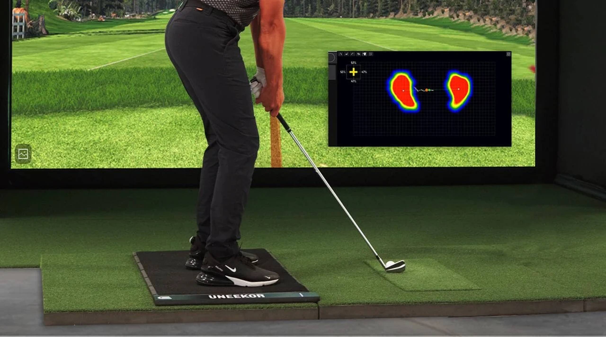 Golfer on a Uneekor pressure mat in a simulator, with a foot pressure heat map display.