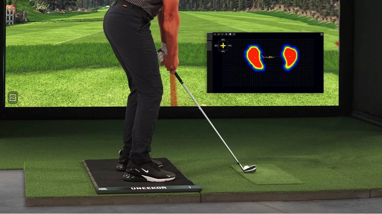 Golfer on a Uneekor pressure mat in a simulator, with a foot pressure heat map display.