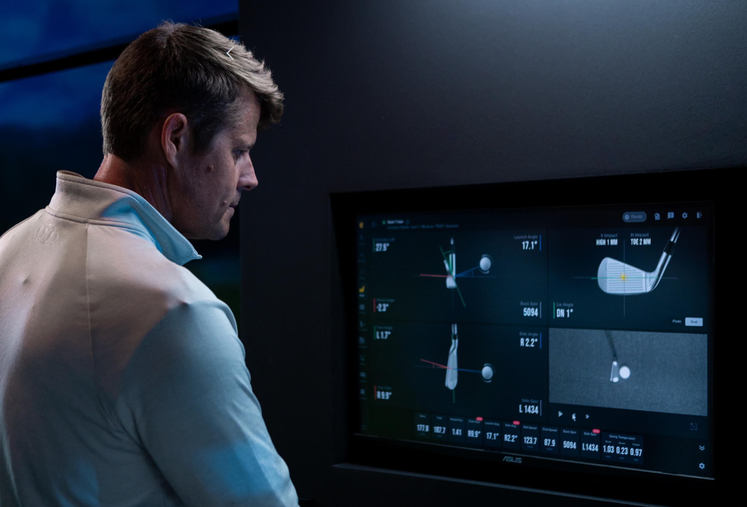 Man views golf swing data on a screen.