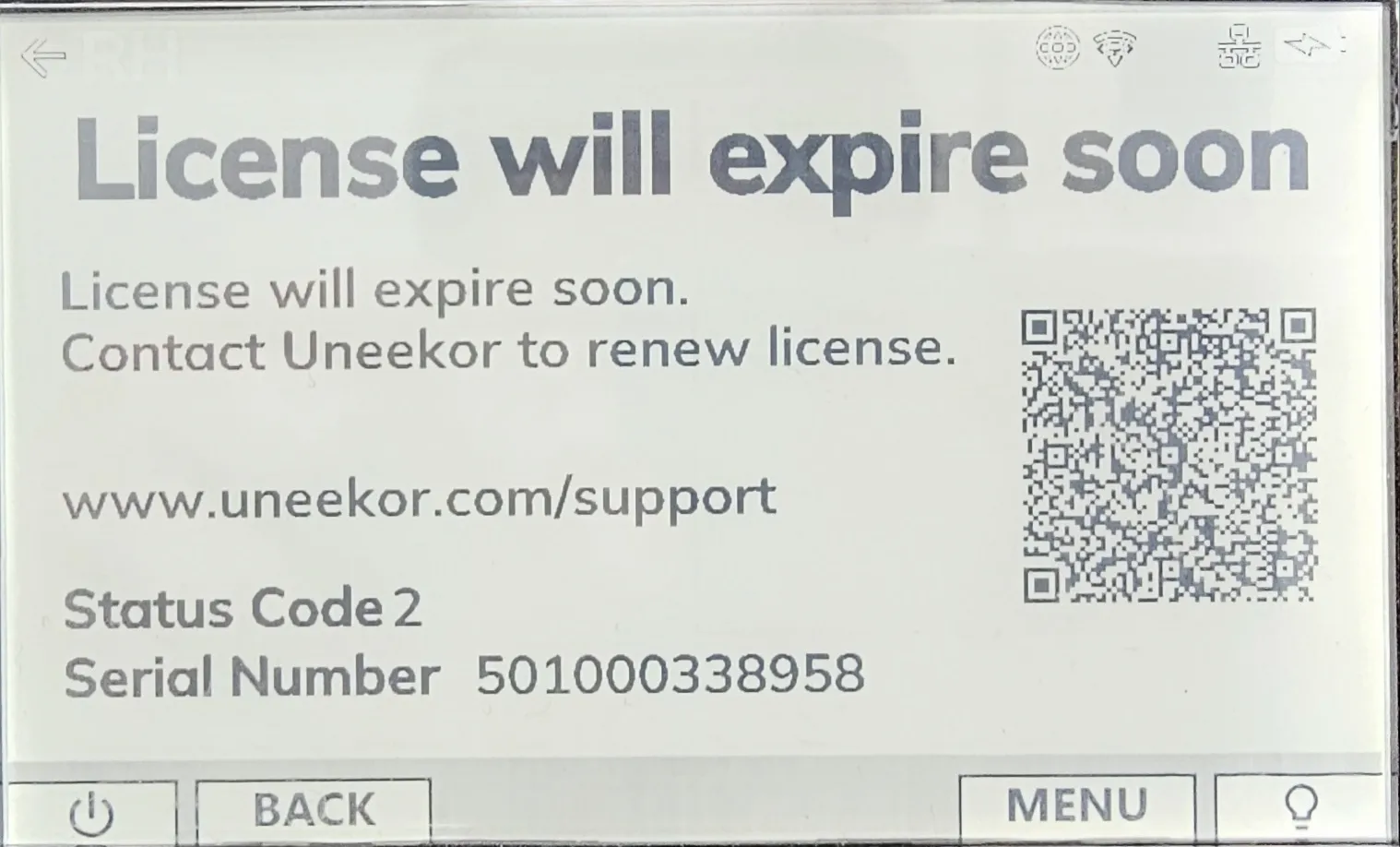 Digital display with a "License will expire soon" message, Uneekor support details, a QR code, and a serial number.