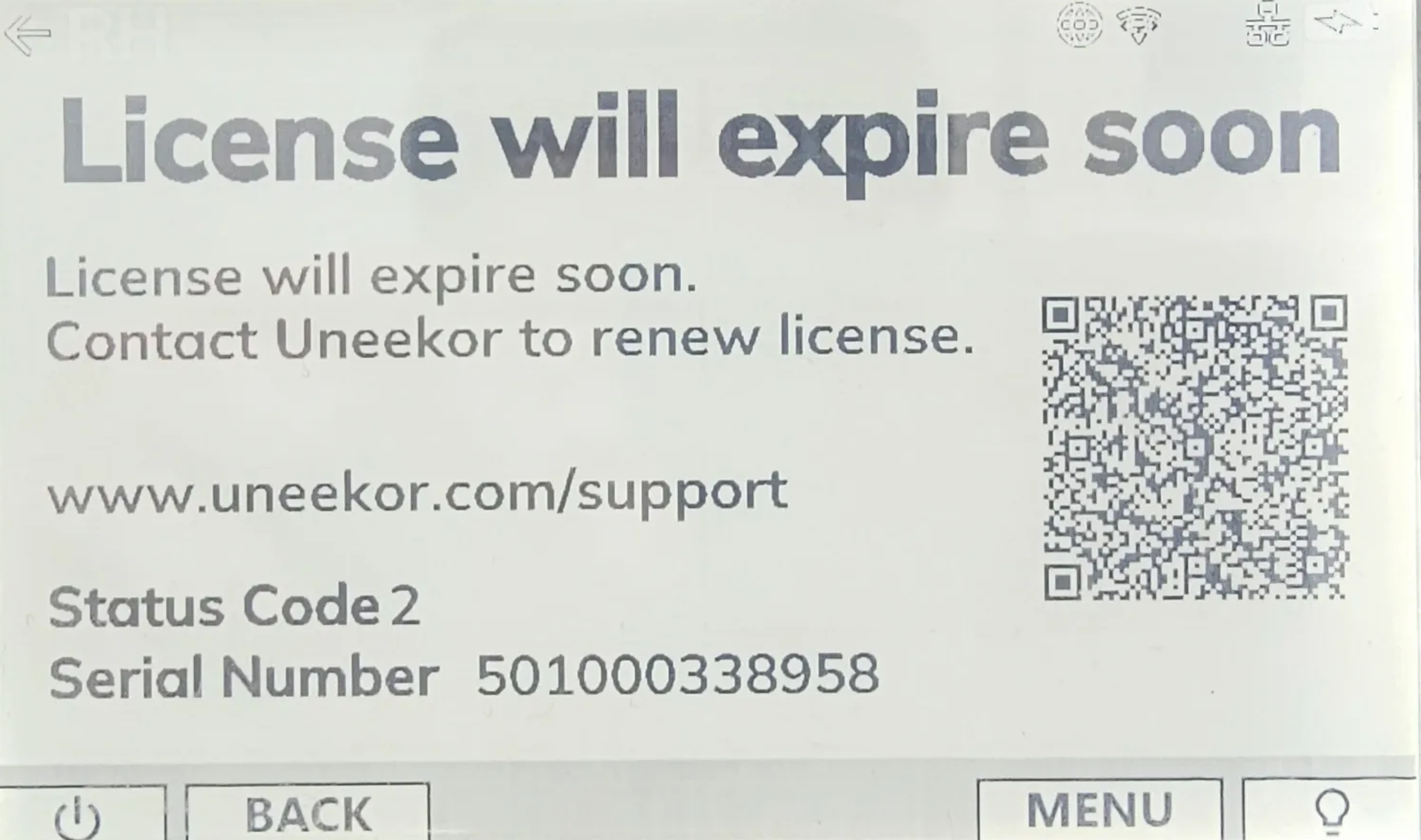 Digital display with a "License will expire soon" message, Uneekor support details, a QR code, and a serial number.