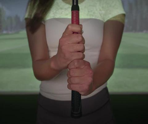 Hände, die in einem Golfsimulator einen Golfschläger halten.