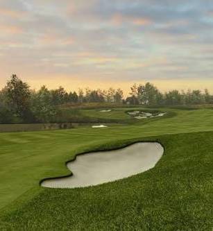Golf course with green fairways, sand bunkers, a pond, and trees at sunset.