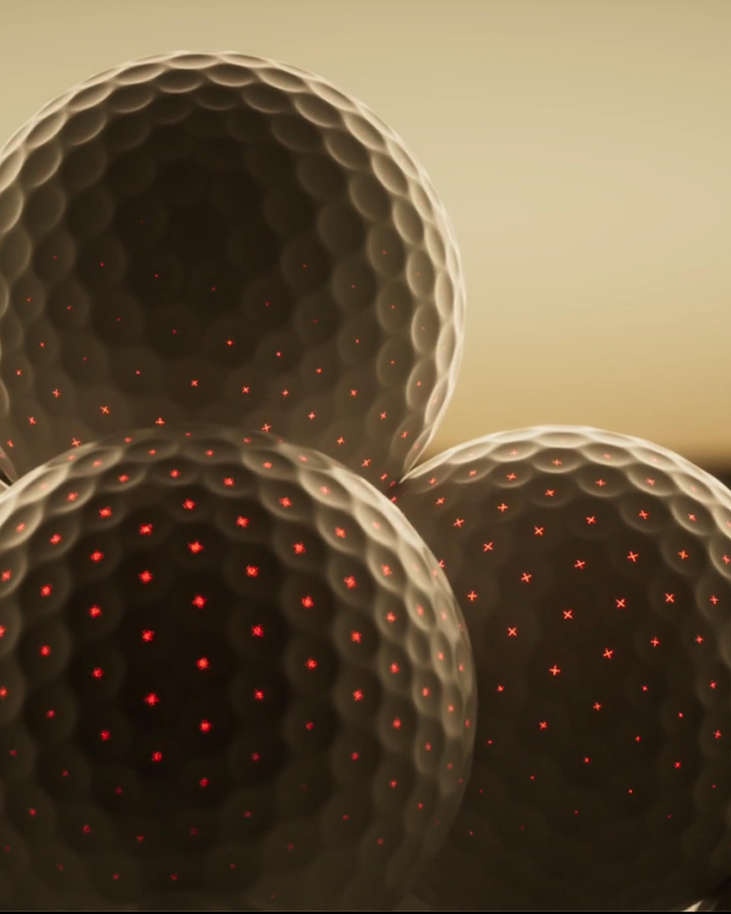 Close-up of three dark golf balls with glowing red 'X' marks in their dimples.