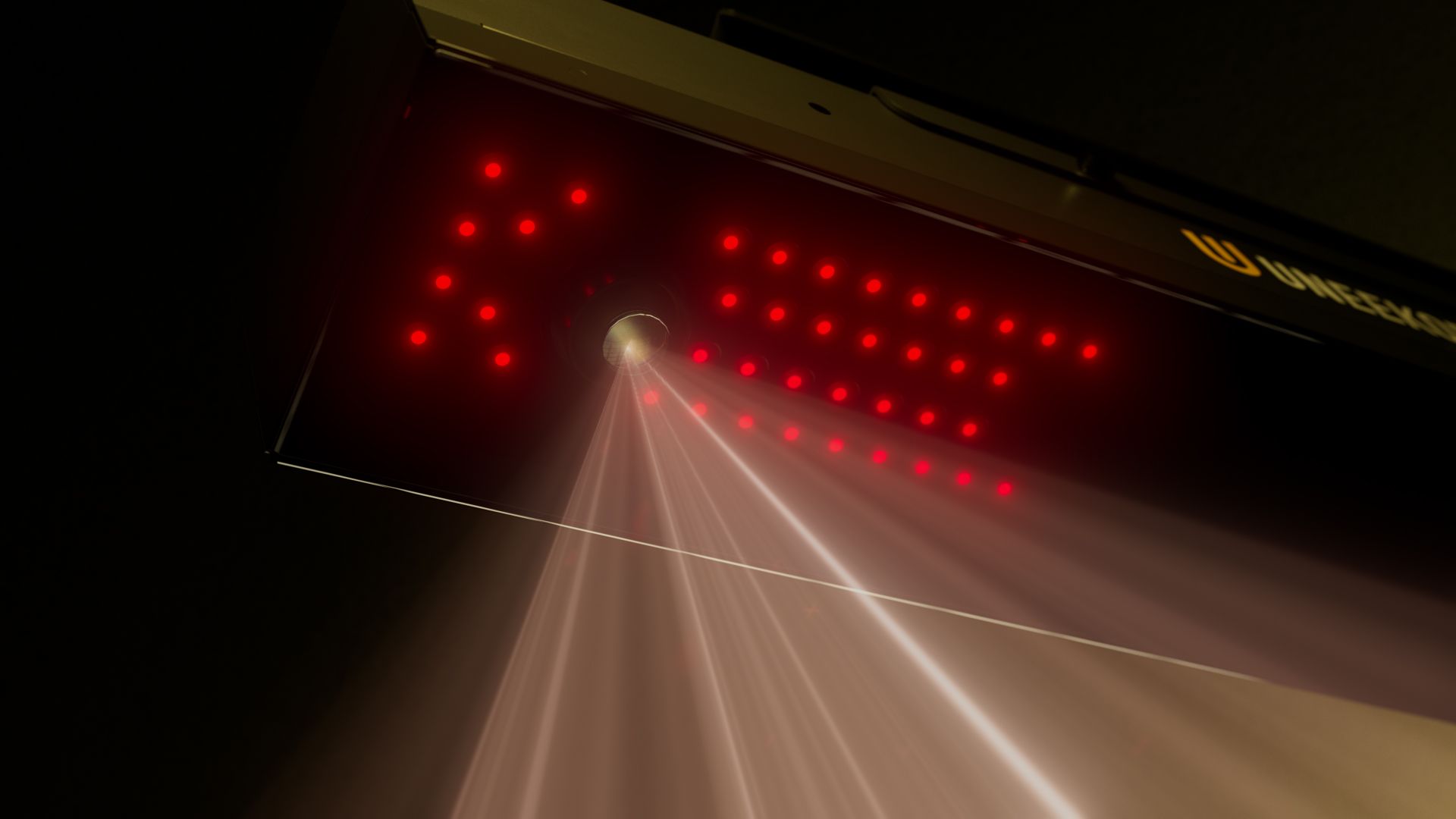 A scanner device with red LED lights forming an arrow shape emits multiple red light beams, with "UNIQUESCAN" visible on its surface.