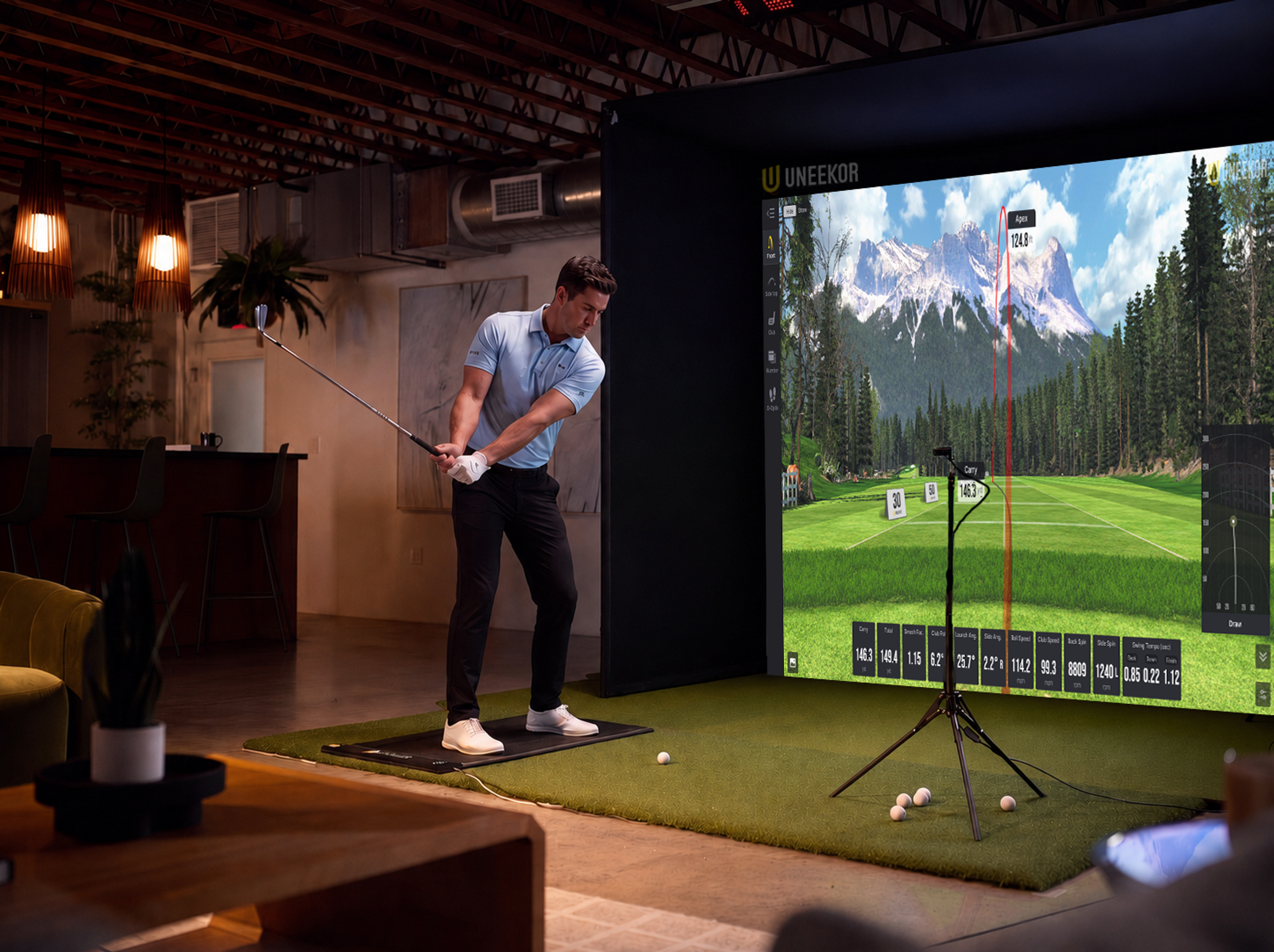 Man playing golf on an indoor simulator displaying a virtual mountain course.