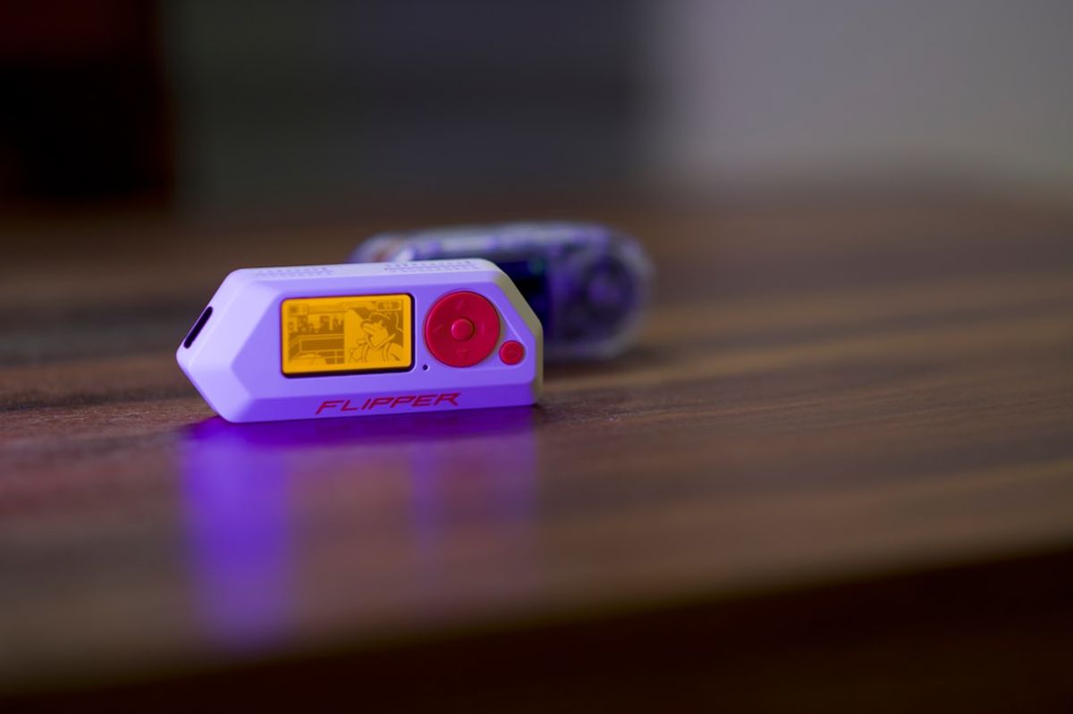 Two small electronic devices on a wooden surface.