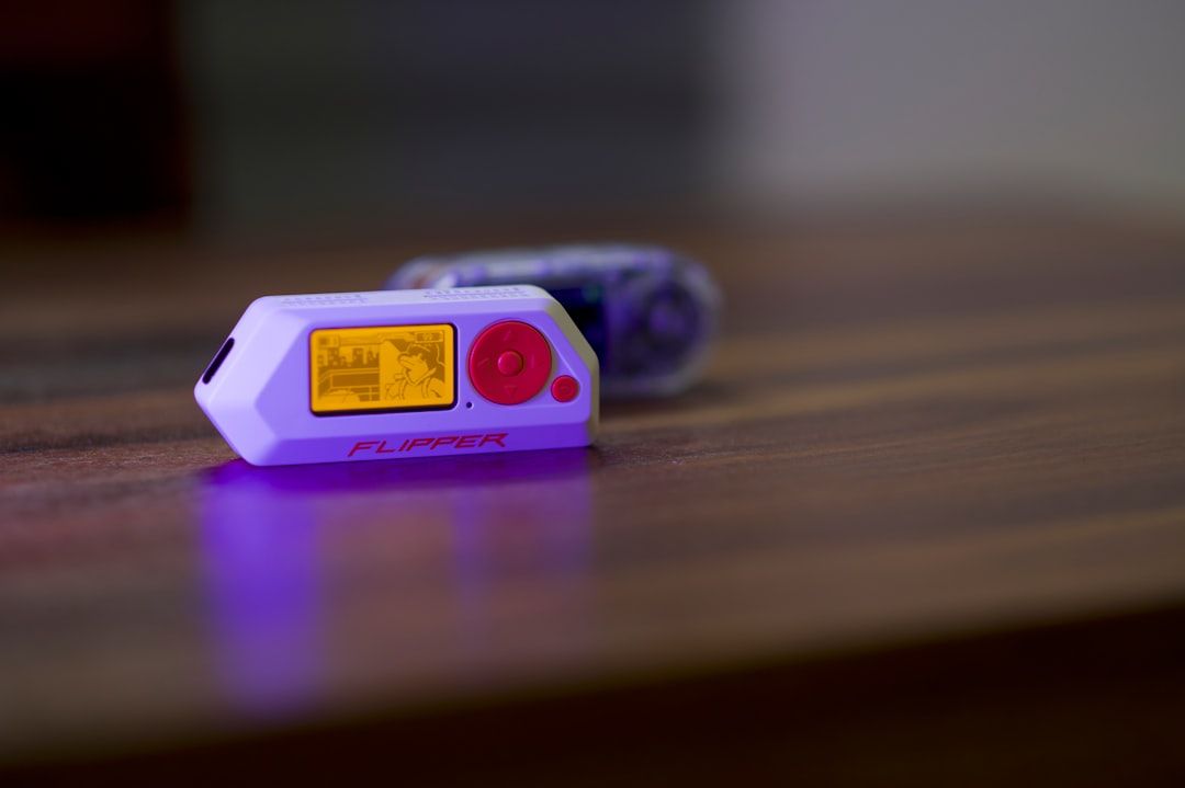 Two small electronic devices on a wooden surface.