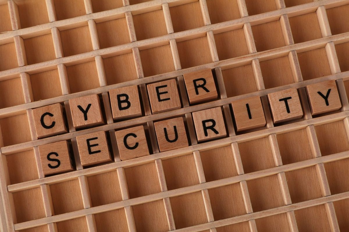 Wooden blocks spelling 'Cyber Security' on a wooden grid background.