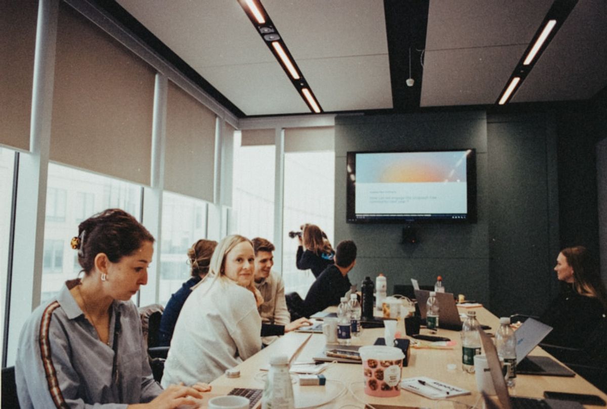 a group of people sitting at a long table