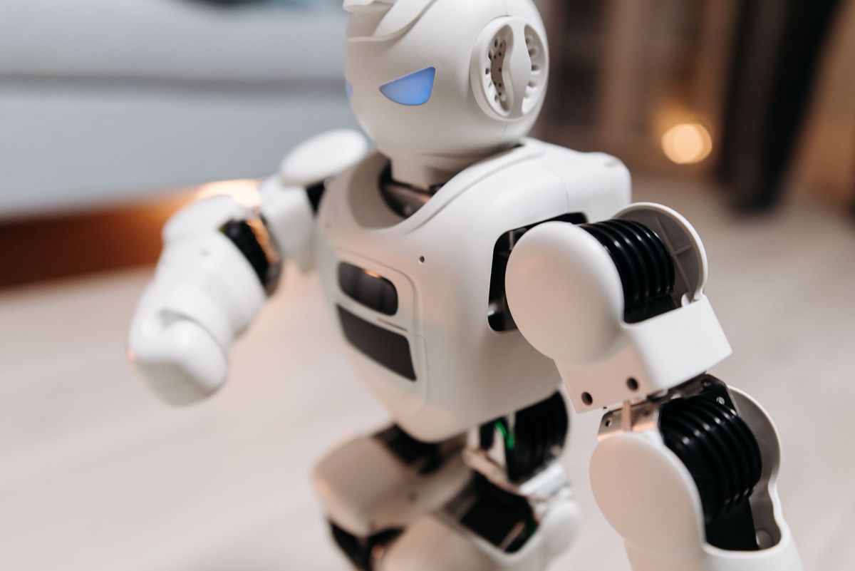 Close-up of a futuristic toy robot with blue eyes, showcasing modern technology indoors.