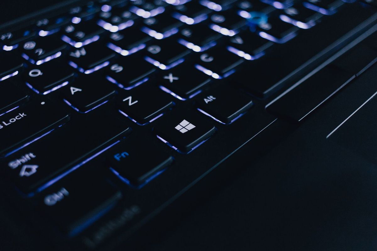 Detailed view of an illuminated laptop keyboard showing individual keys and backlight effect.