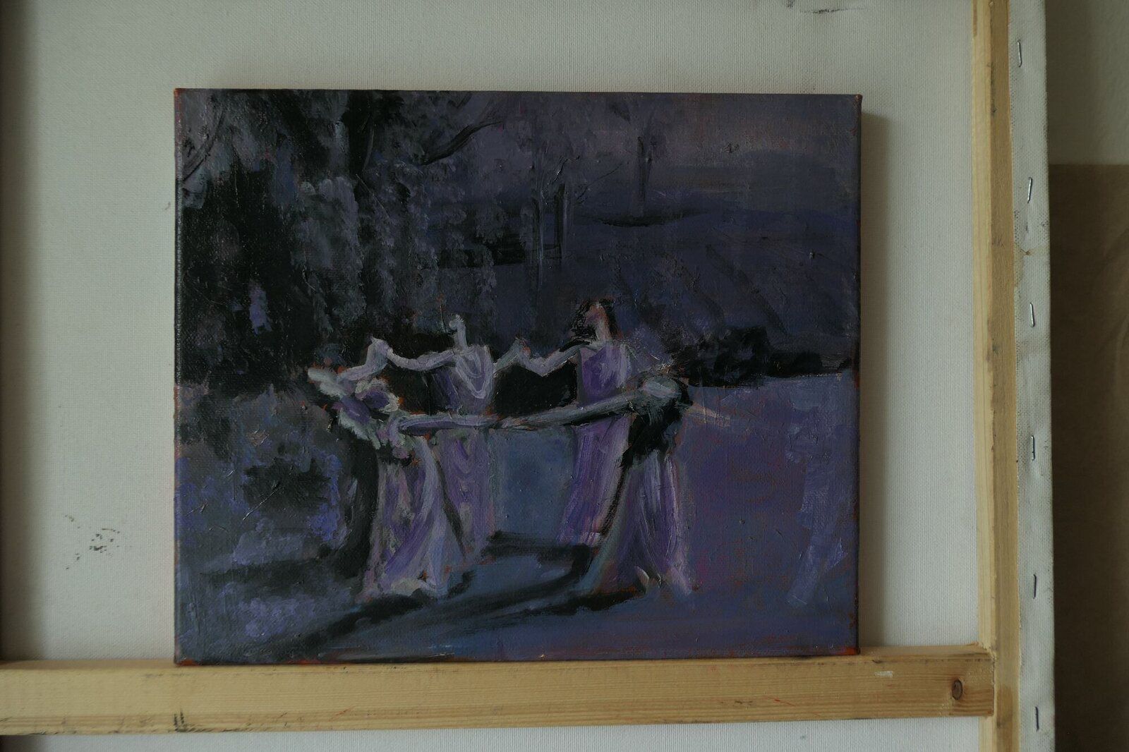 Figures gathered along a rail in a dark violet interior