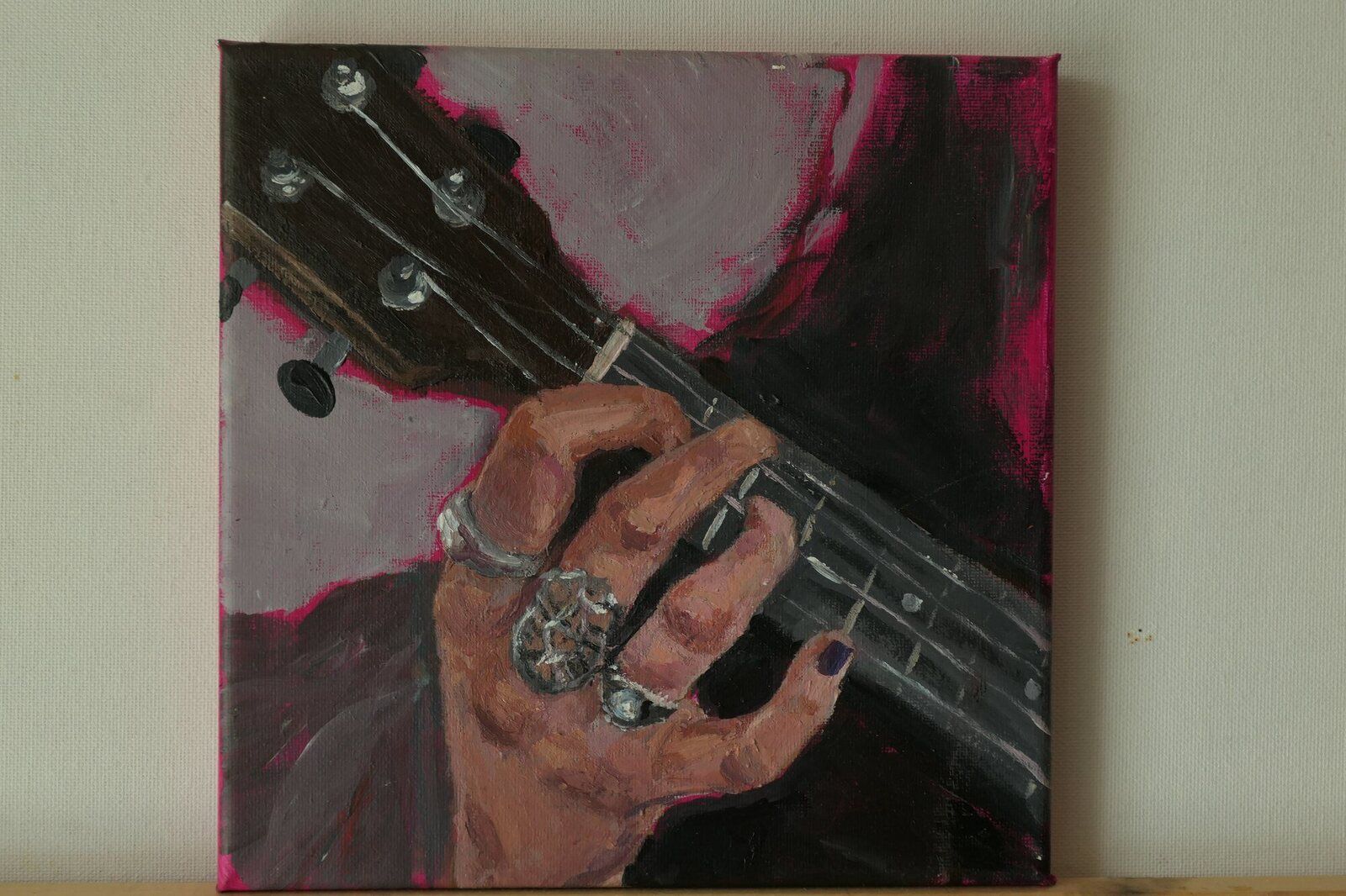 A Hand with rings playing ukulele