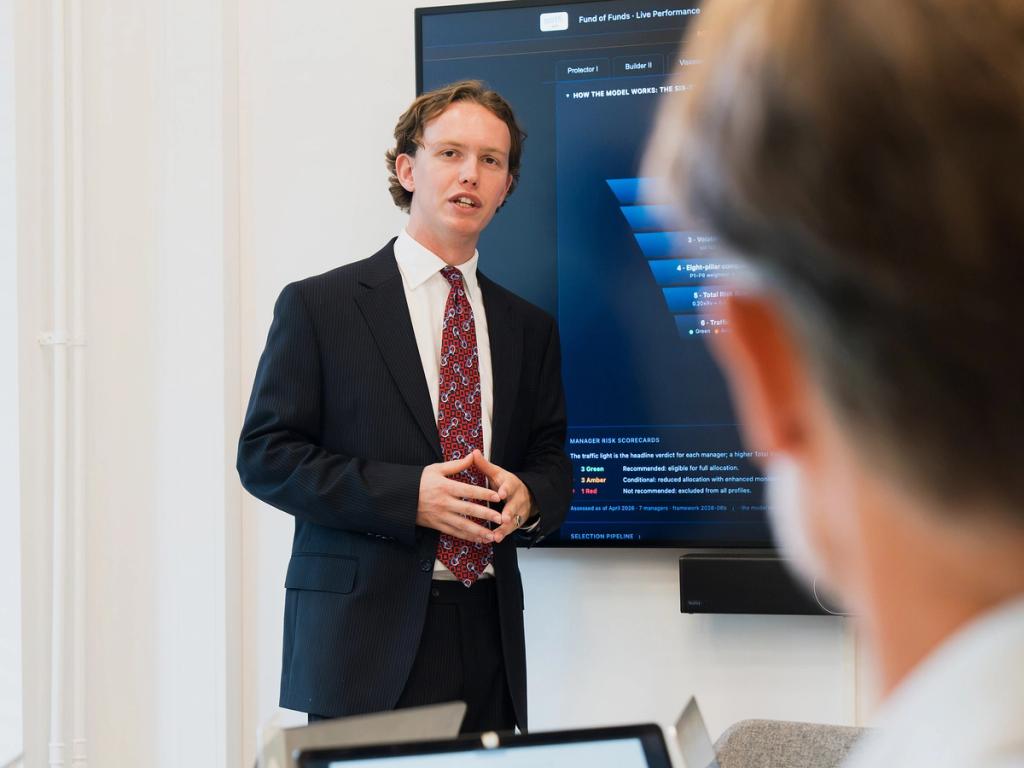 Investment professional beoordeelt fondsrapportages en grafieken aan een werktafel