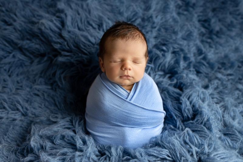 Miminko v modrém wrapu na modré kožešině, studio Praha.