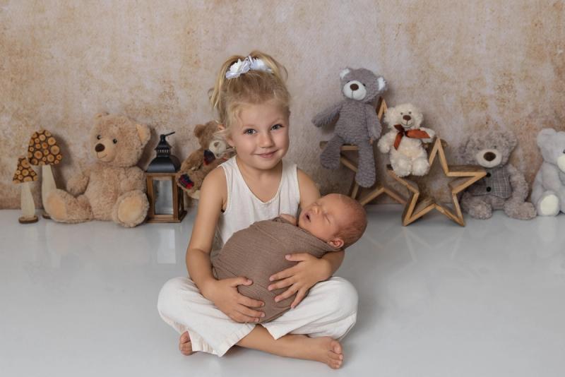 Sourozenci, holčička drží novorozence s plyšáky, studio Praha.