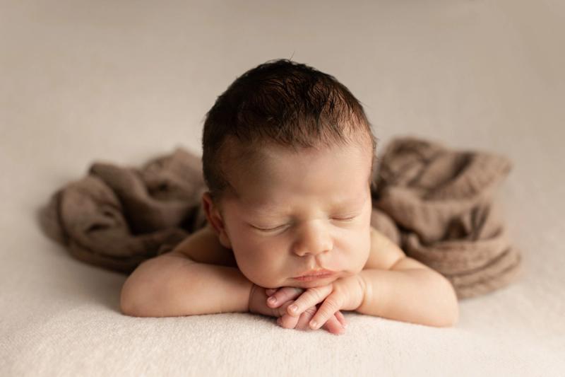 Miminko na bříšku na karamelové dece, portrét z ateliéru.