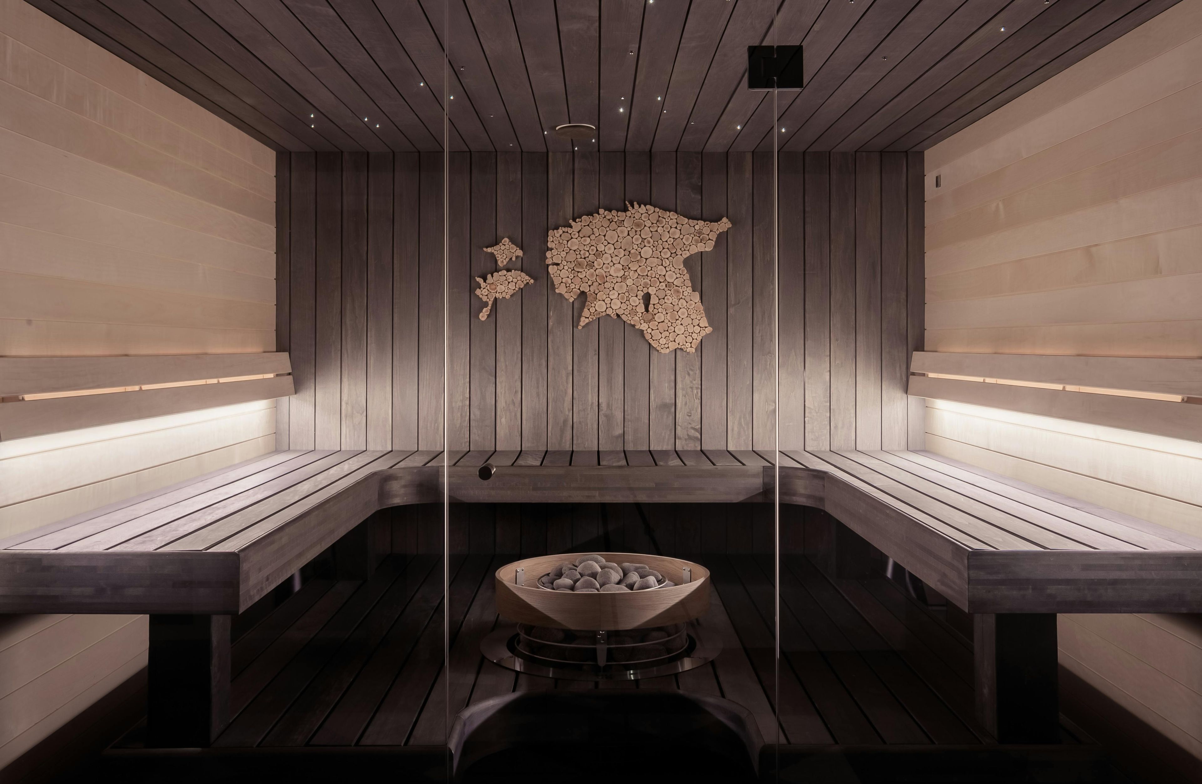 En dame i badstue, med utsikt over skogen.