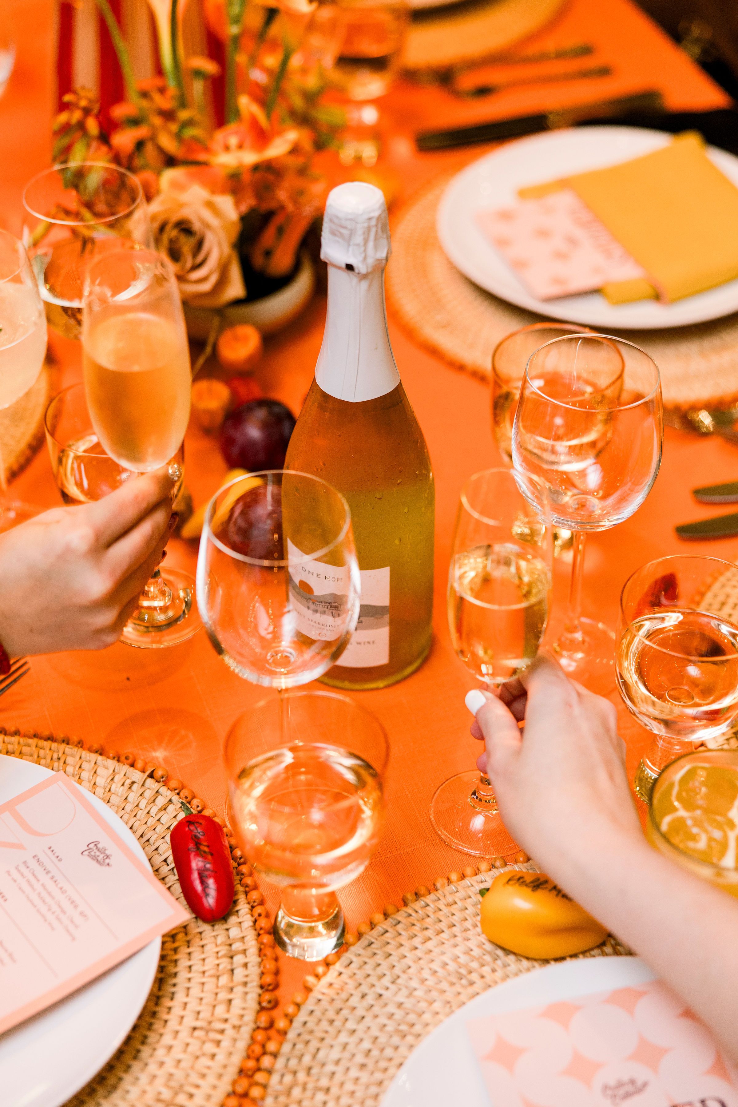 Orange monochromatic tablescape dinner party with champagne glass cheers