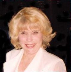 A picture of a blond woman smiling at the camera