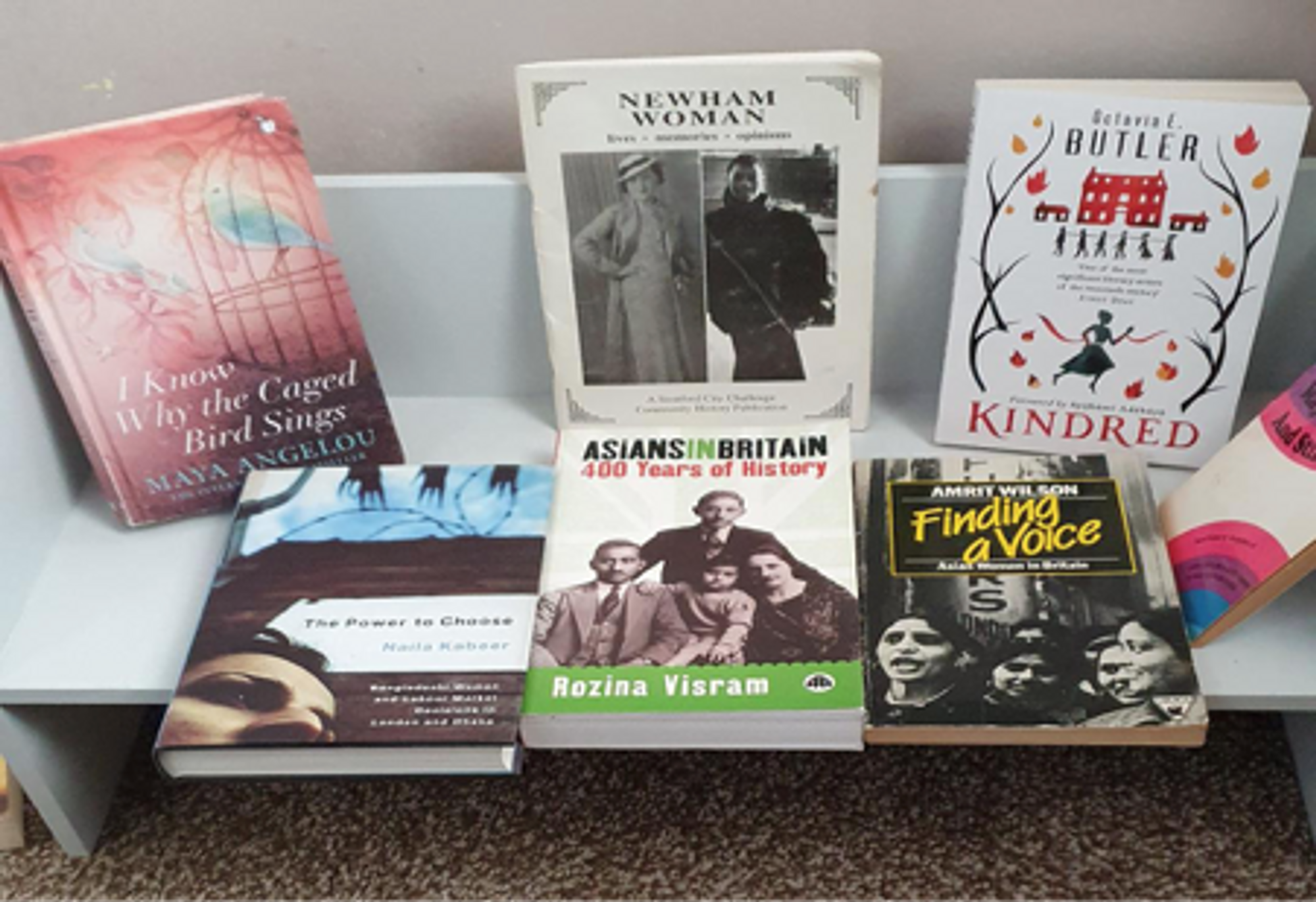 Selection of books by women authors on a freestanding shelf