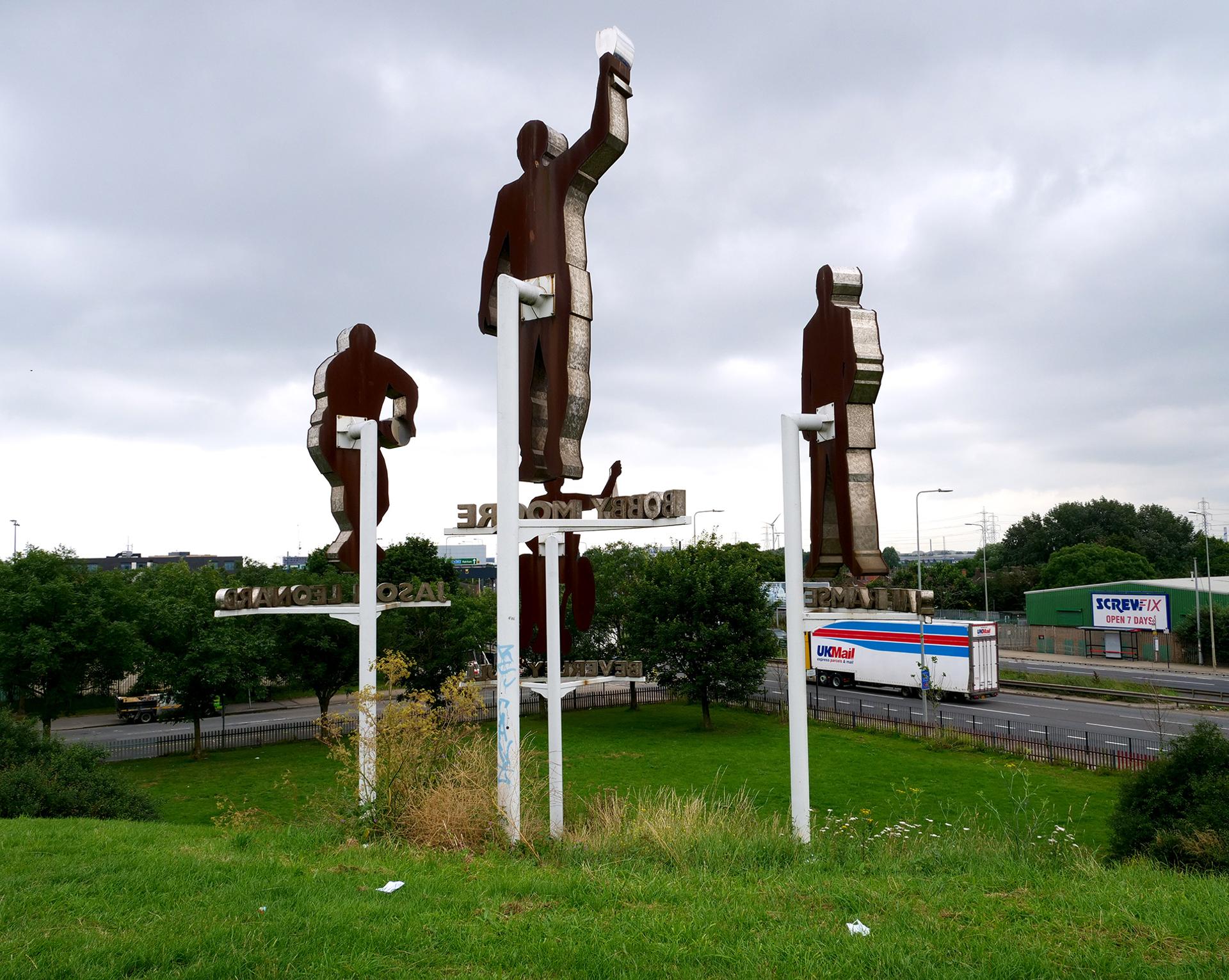 Statues of ex-England football captain Bobby Moore, manager Sir Alf Ramsay, international rugby player Jason Leonard, and champion Paralympic swimmer Beverley Gull, at Castle Green near the A13.