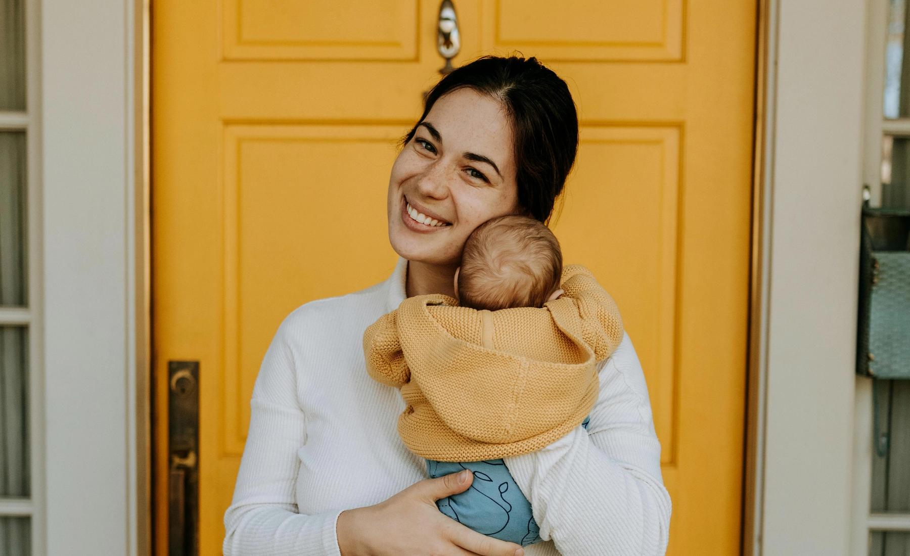 Sarah M. holding her new baby at home.