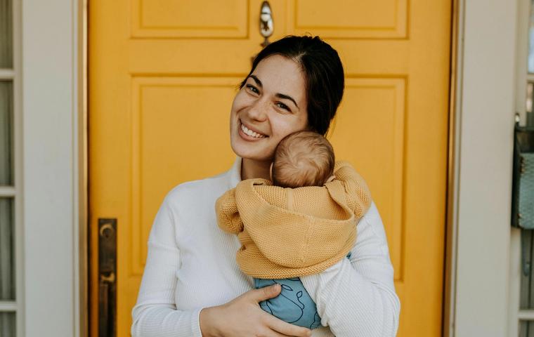 Sarah M. holding her new baby at home.