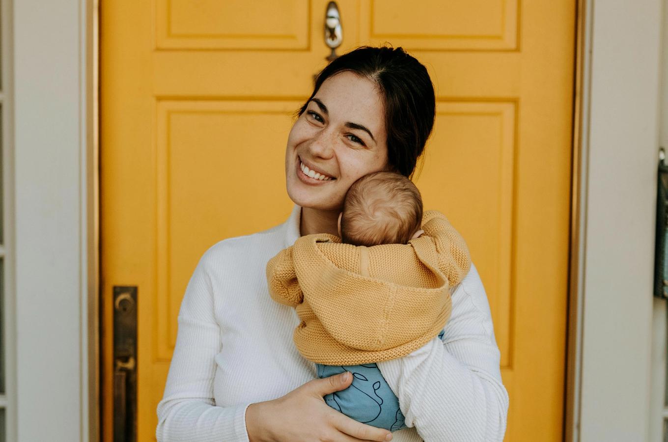 Sarah M. holding her new baby at home.