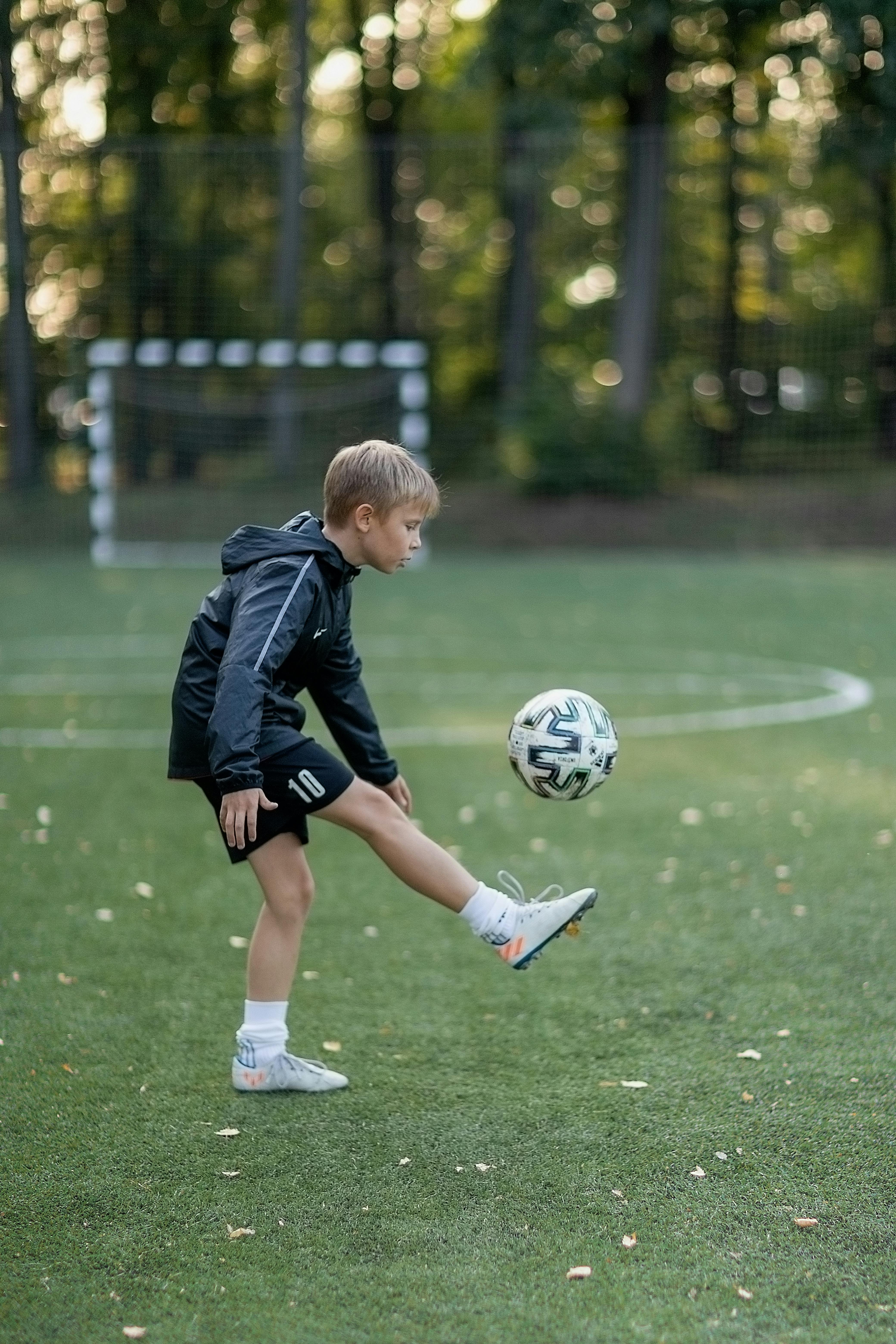 Young soccer player running on a field after recovering from a leg injury with physiotherapy