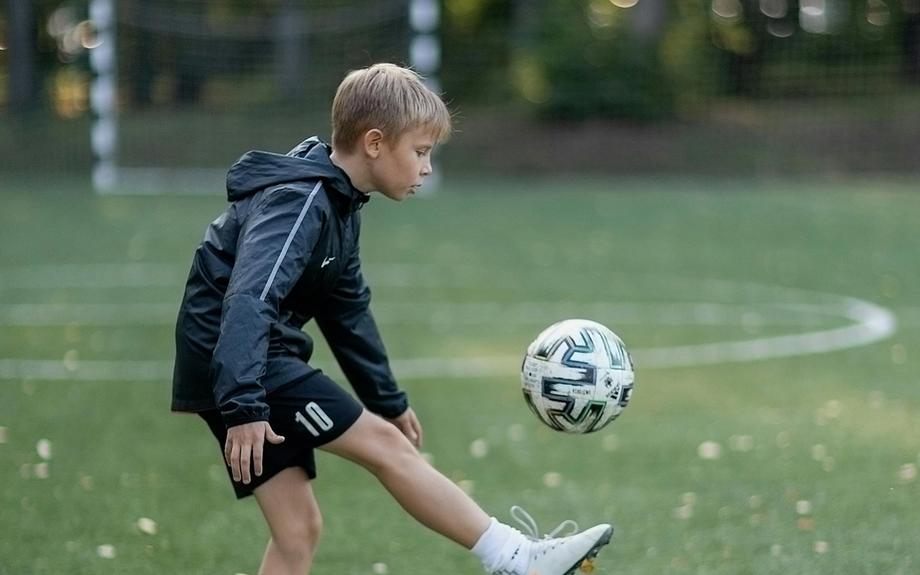 Young soccer player running on a field after recovering from a leg injury with physiotherapy