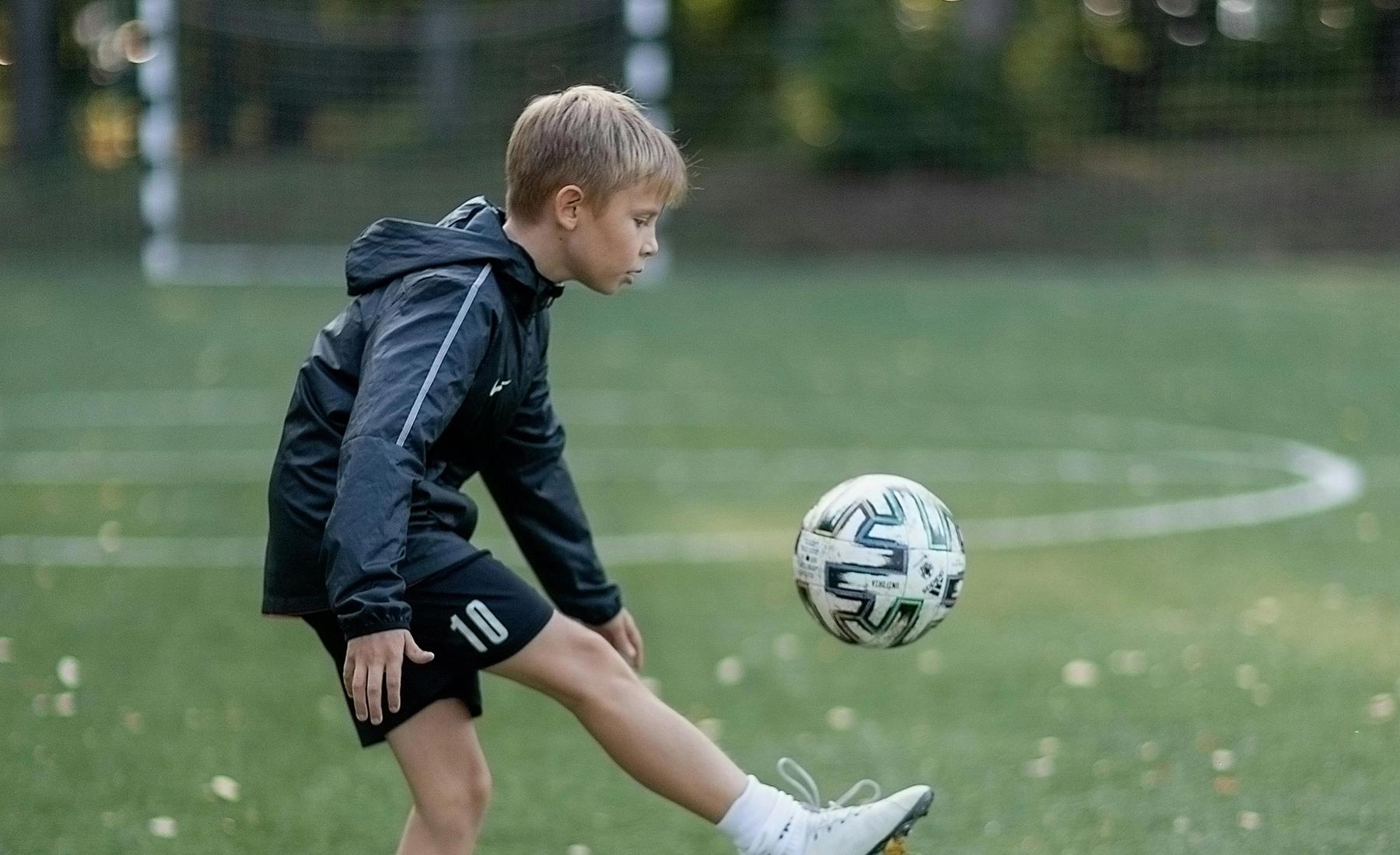 Young soccer player running on a field after recovering from a leg injury with physiotherapy