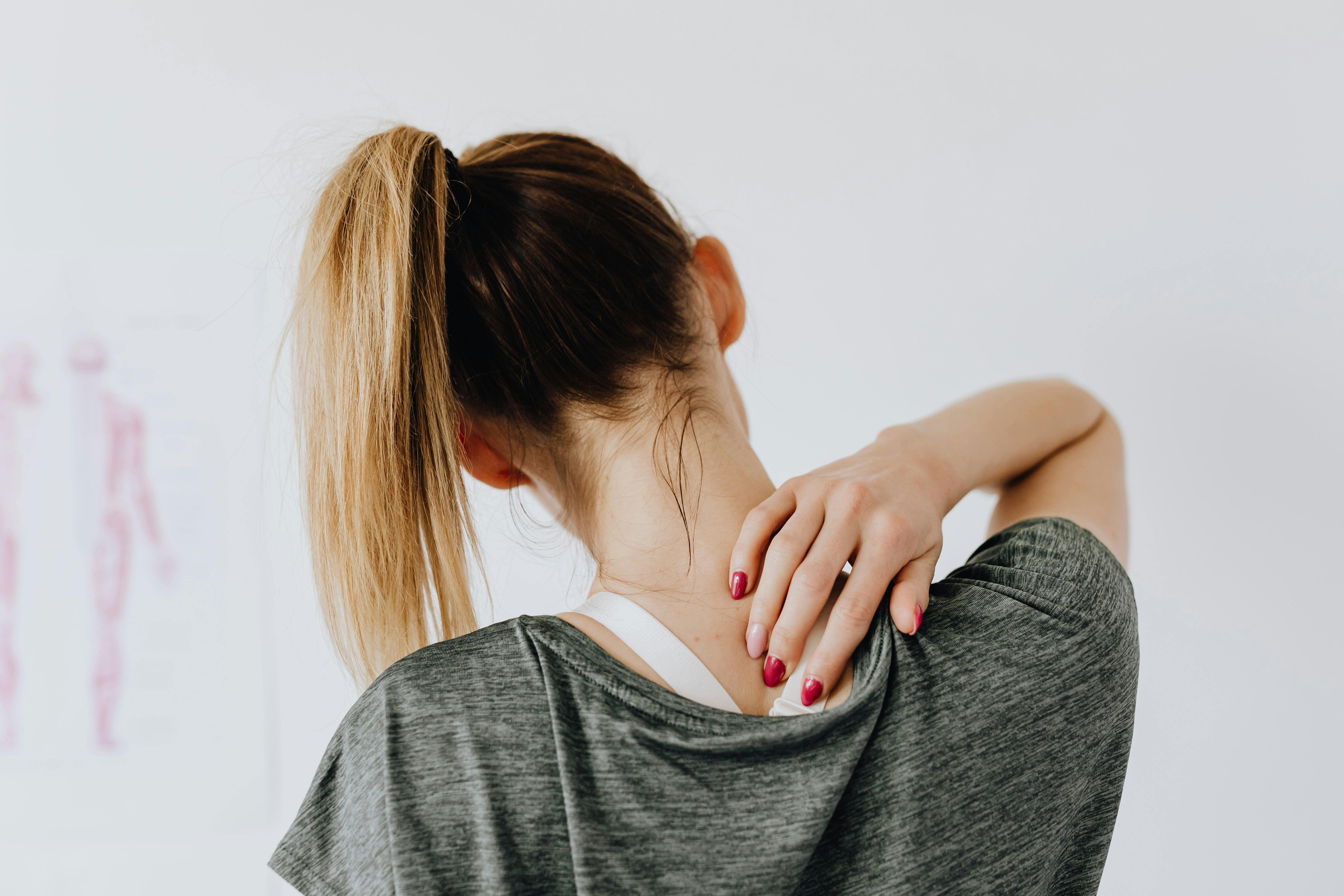 Physiotherapist performing hands-on manual therapy on a patient’s shoulder in a clinic