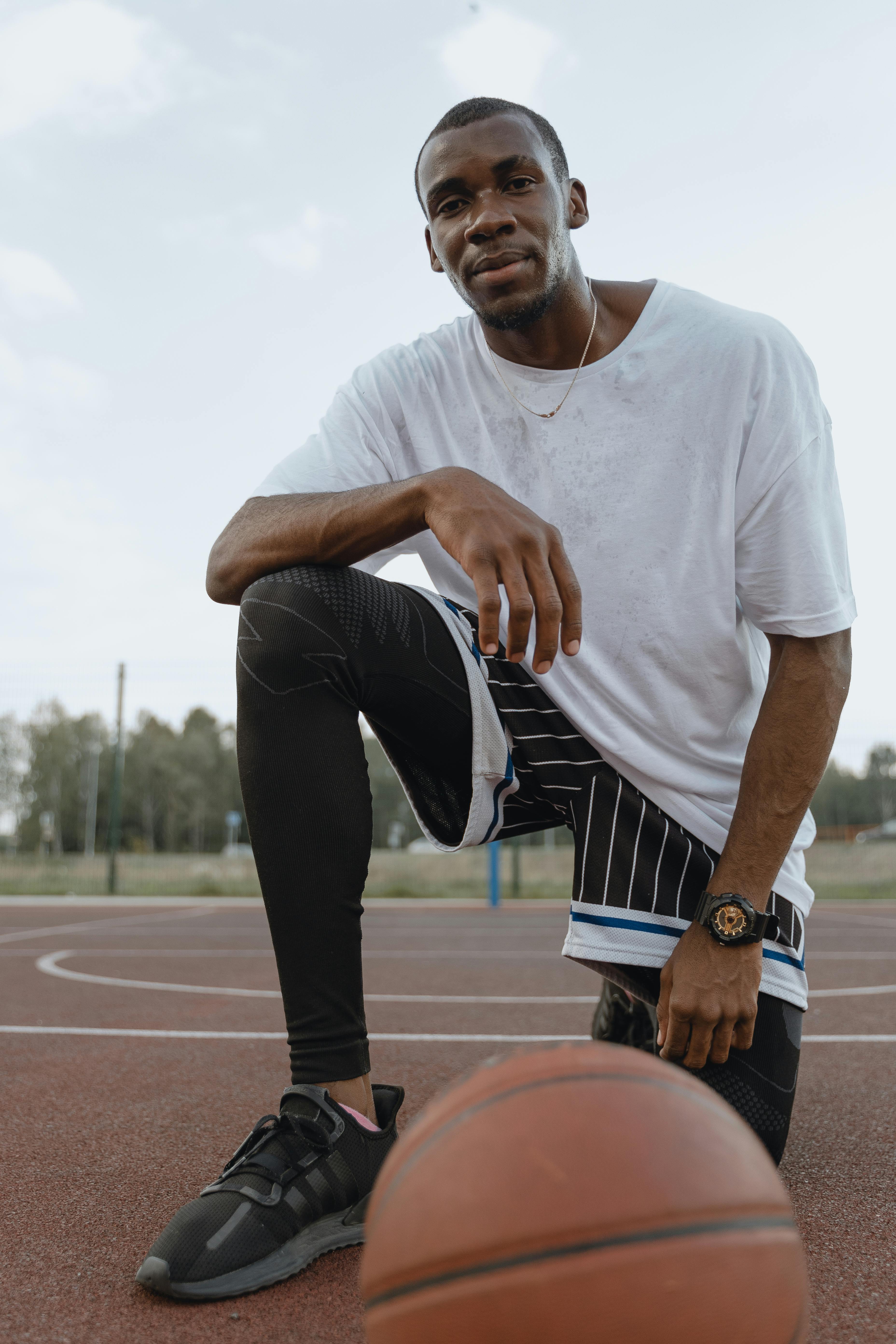 Marcus L. kneeling on a basketball court.