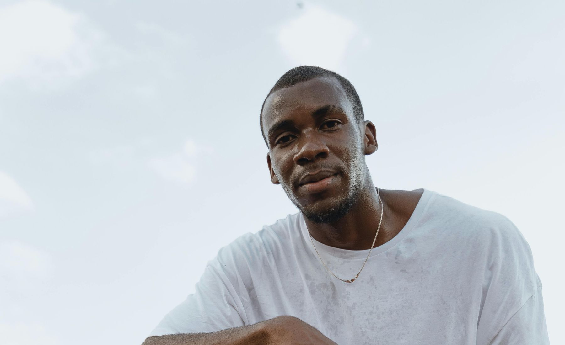 Marcus L. kneeling on a basketball court.