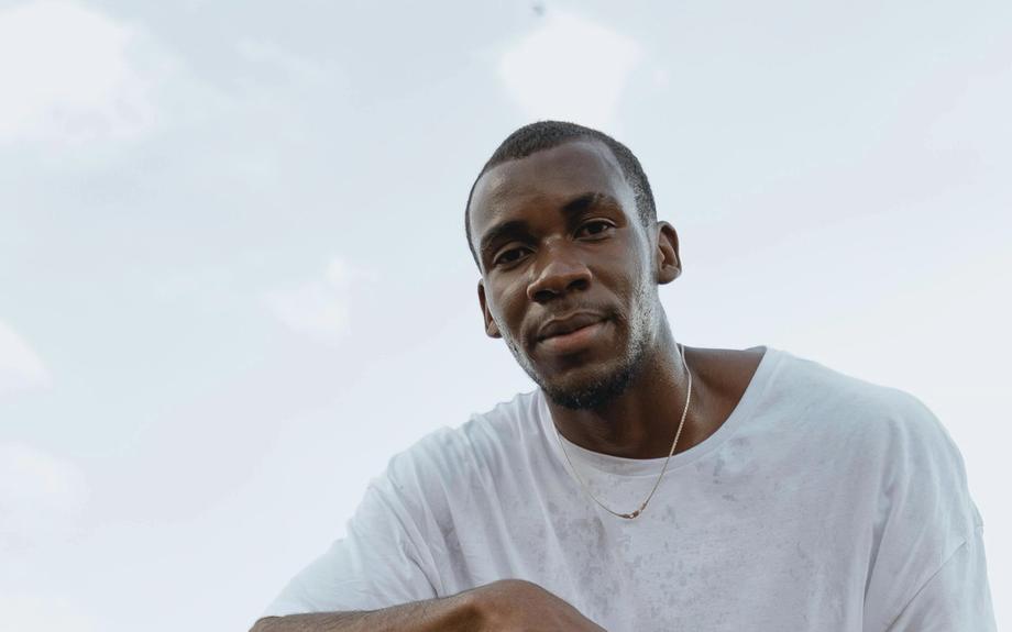 Marcus L. kneeling on a basketball court.