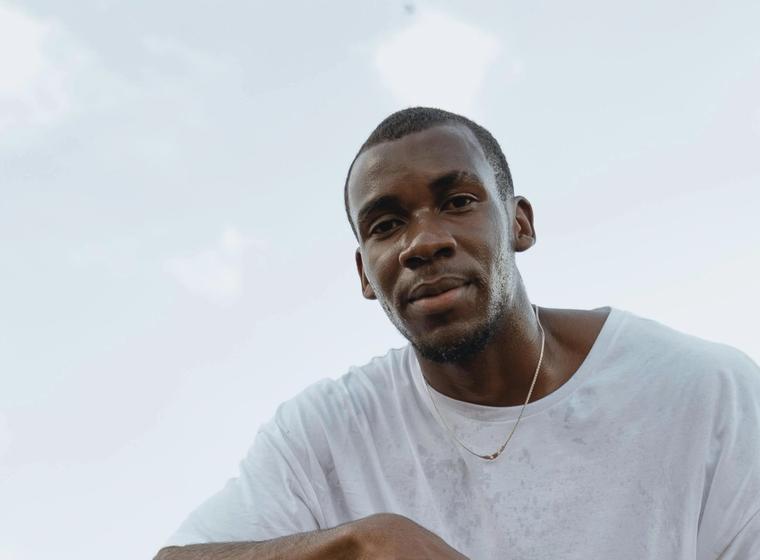 Marcus L. kneeling on a basketball court.